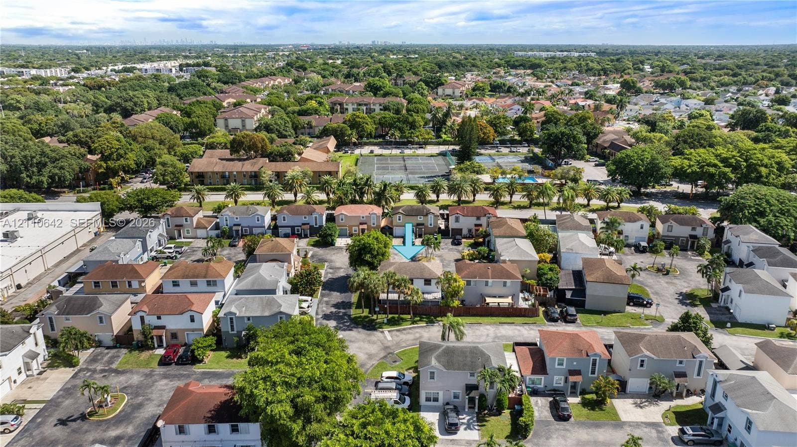 14732 SW 90th Terrace, Miami, FL 33196 Aerial perspective of a multi-unit residential property featuring a pitched roofline, paved driveway, and established surrounding greenery