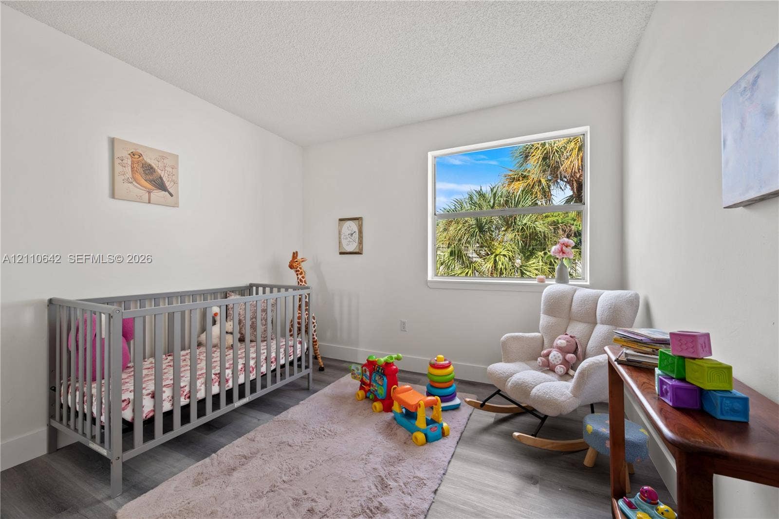 14732 SW 90th Terrace, Miami, FL 33196 Neutral wall finishes, wood-finish flooring, and a single-pane window with tropical landscape scenery