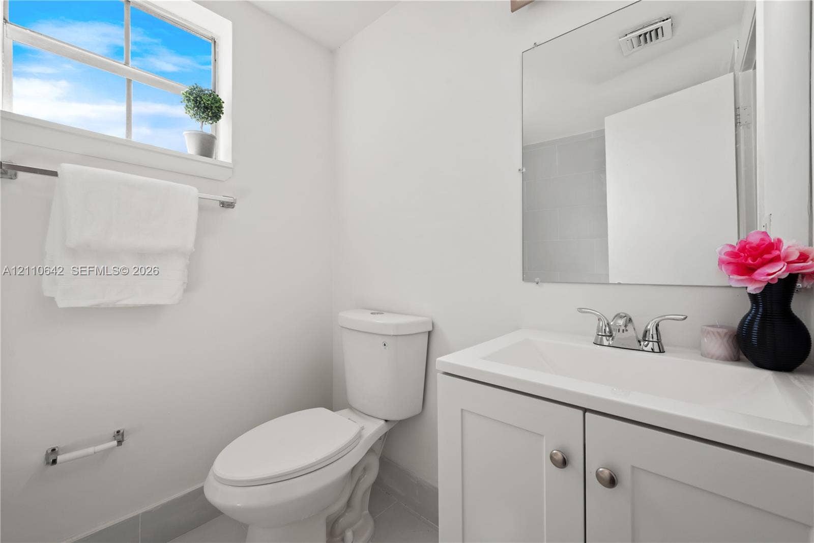 14732 SW 90th Terrace, Miami, FL 33196 White vanity with an integrated sink and chrome hardware, framed mirror, and a multi-pane window