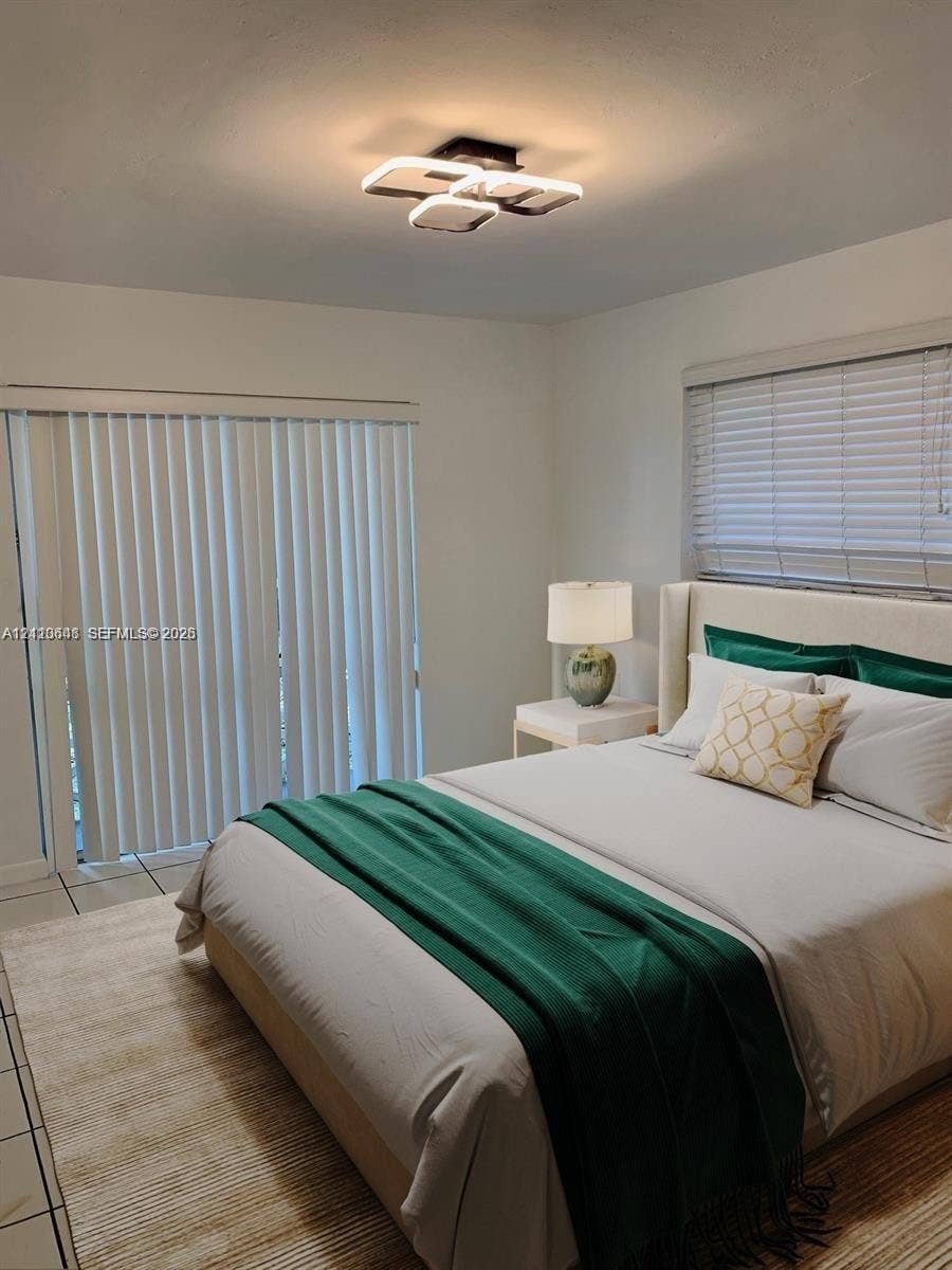Contemporary geometric LED flush-mount ceiling fixture, neutral tile flooring, sliding vertical blinds, and horizontal window blinds