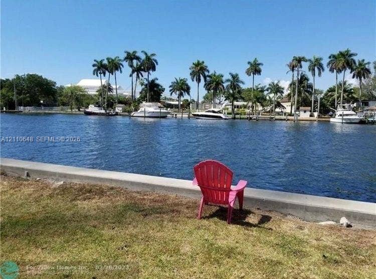 Waterfront property featuring a concrete bulkhead and lawn area