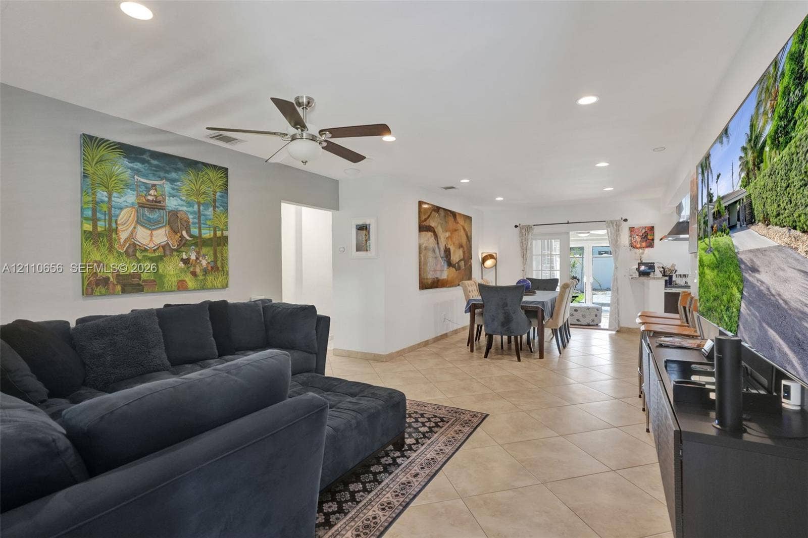 30 NE 48th Court, Oakland Park, FL 33334 Open-concept interior featuring light-toned tile flooring, recessed ceiling lighting, and a multi-blade ceiling fan