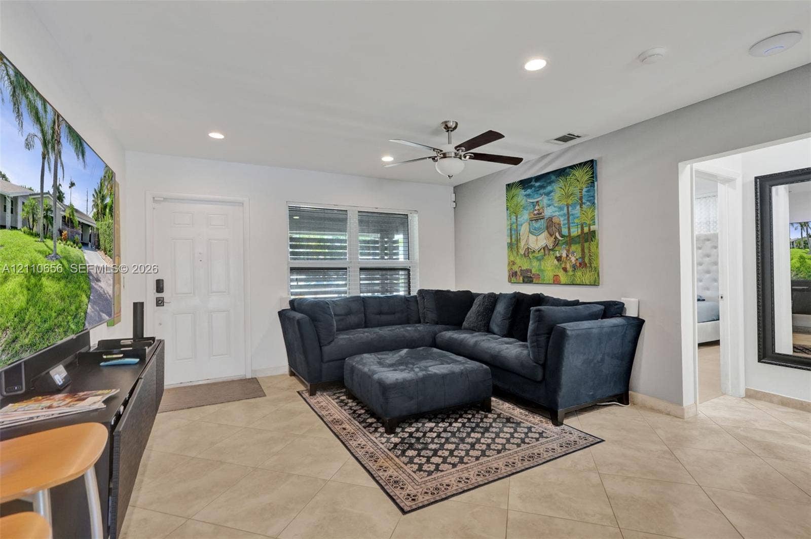 30 NE 48th Court, Oakland Park, FL 33334 Neutral ceramic tile flooring, recessed lighting, multi-blade ceiling fan, and horizontal window blinds
