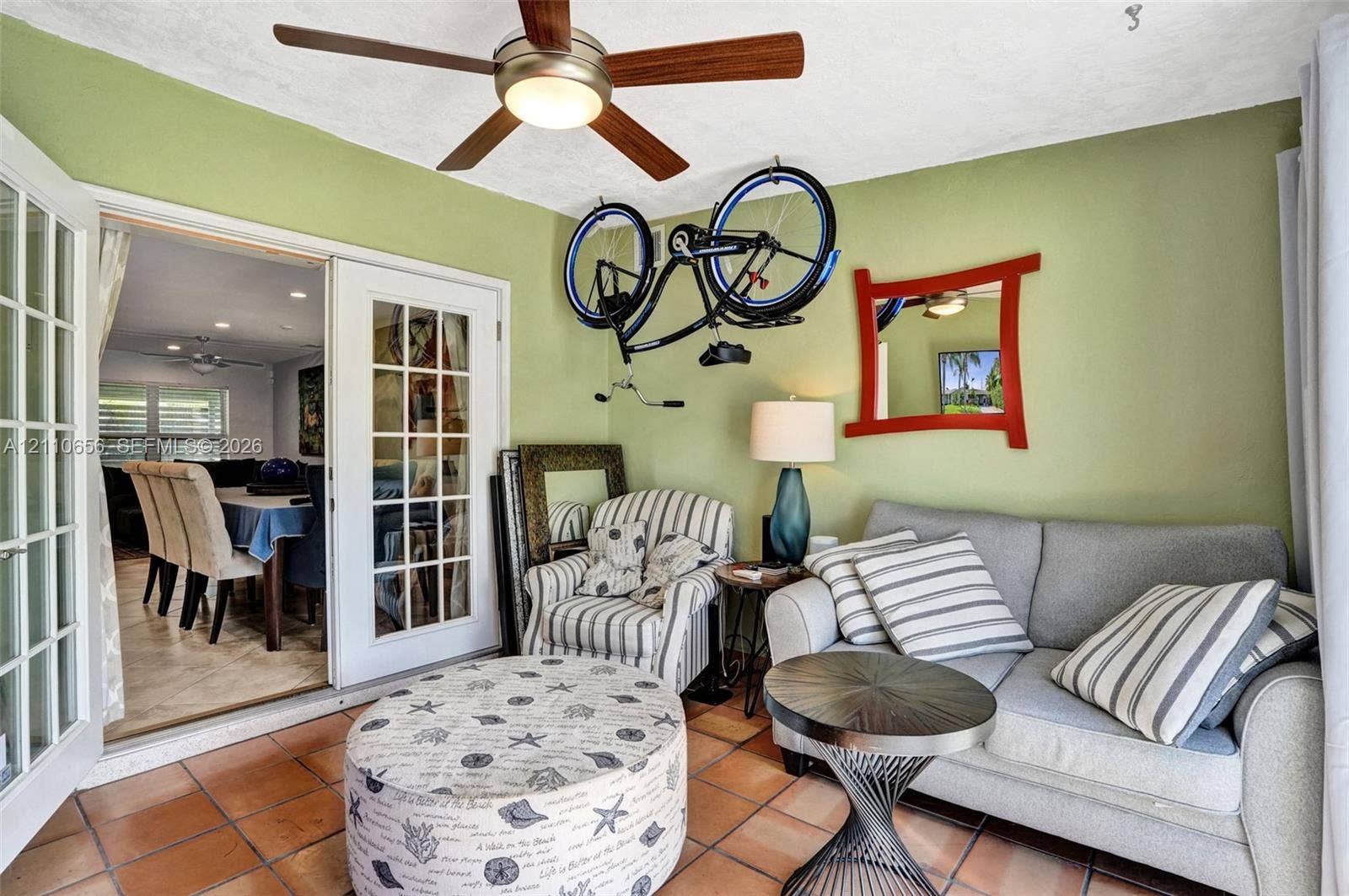 30 NE 48th Court, Oakland Park, FL 33334 Sunroom featuring tile flooring, French doors with glass panes, and a ceiling-mounted light fixture with a multi-blade fan