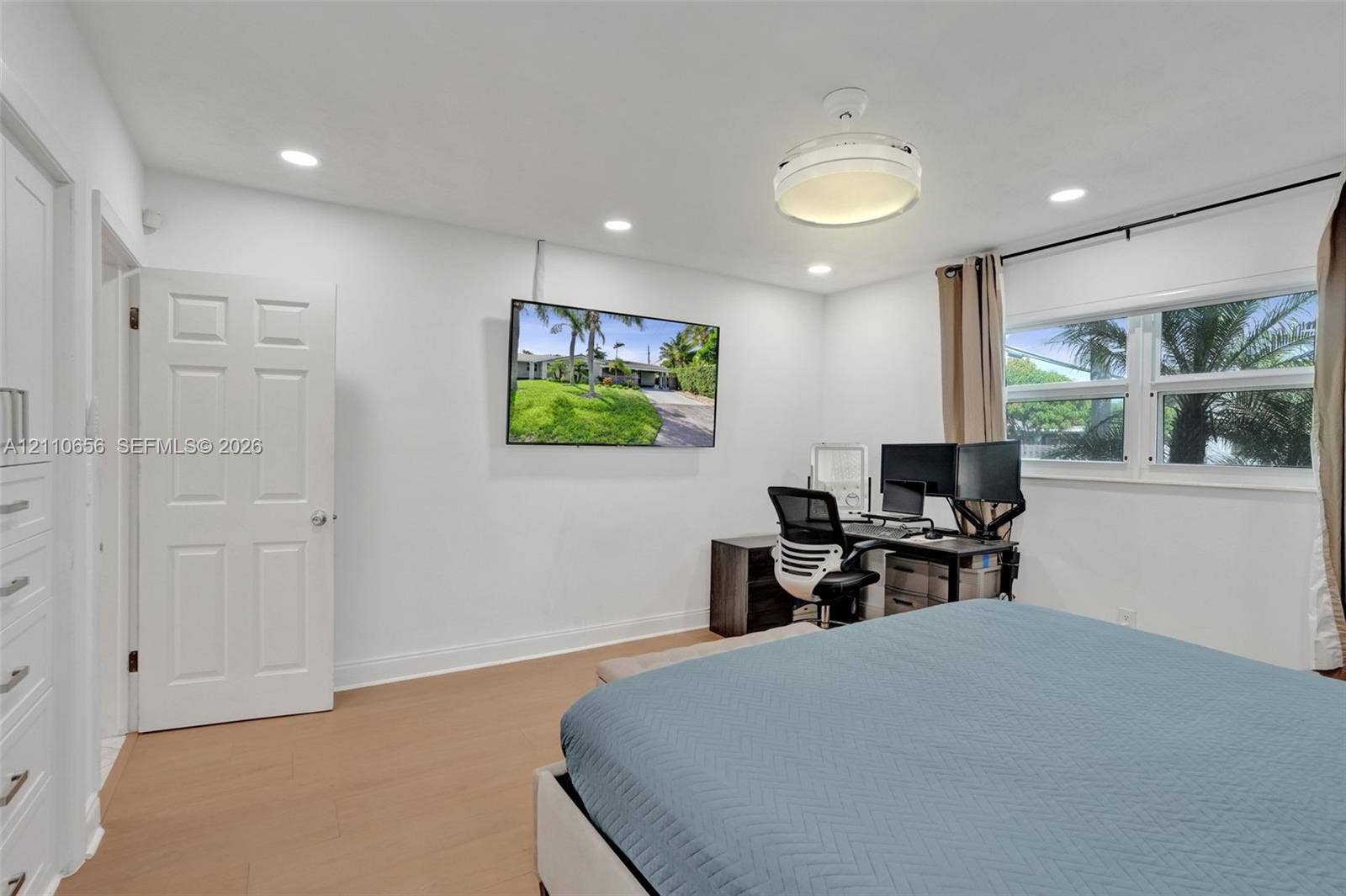 30 NE 48th Court, Oakland Park, FL 33334 Room featuring wood-finish flooring, recessed lighting, a modern ceiling fixture, and a built-in cabinet