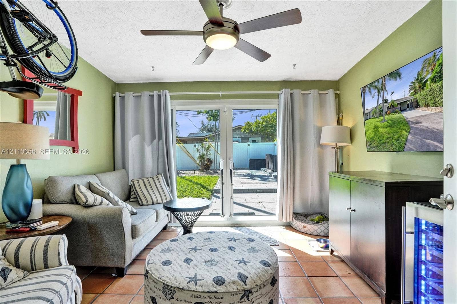 30 NE 48th Court, Oakland Park, FL 33334 Tile flooring, multi-pane glass French doors, and ceiling fan with integrated lighting