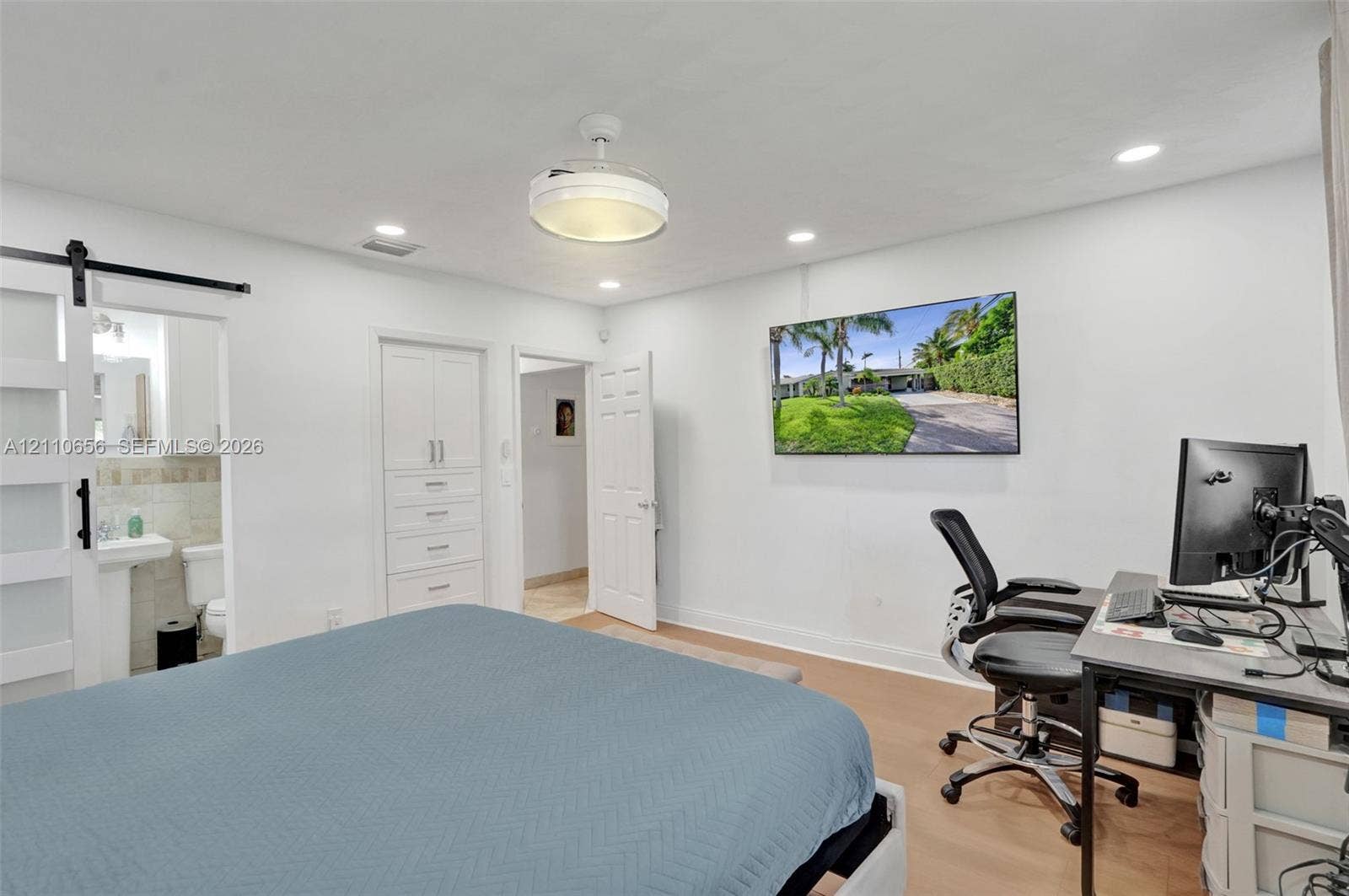 30 NE 48th Court, Oakland Park, FL 33334 Interior space featuring wood-finish flooring, recessed lighting, a ceiling fan with integrated lighting, built-in cabinetry, and a sliding barn door