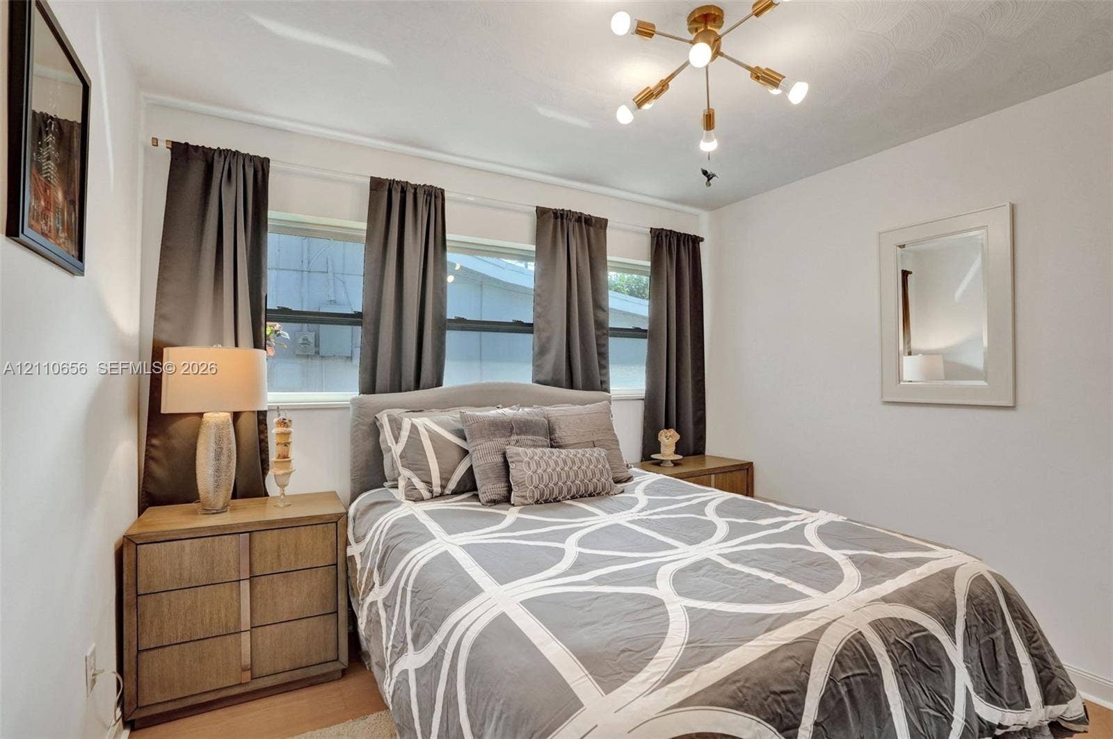 30 NE 48th Court, Oakland Park, FL 33334 Multi-pane windows, brass-finish Sputnik-style chandelier, and neutral wall tones