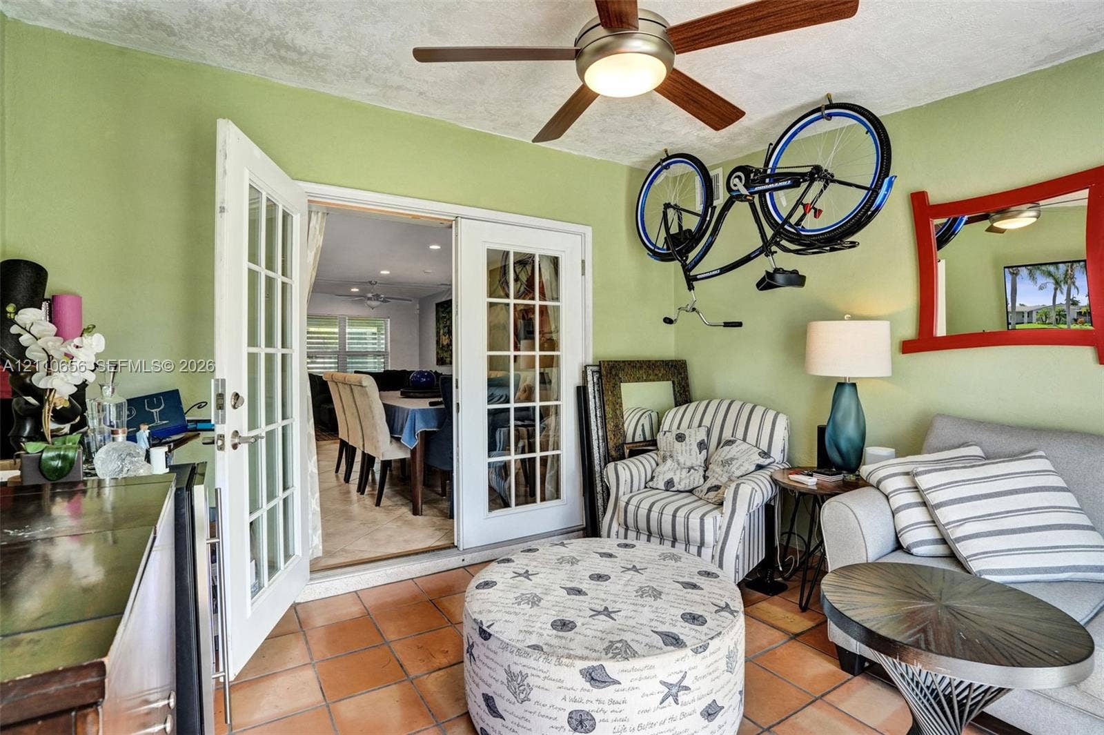 30 NE 48th Court, Oakland Park, FL 33334 Multi-lite glass French doors with white frames, tile flooring, and a ceiling-mounted light fixture with fan