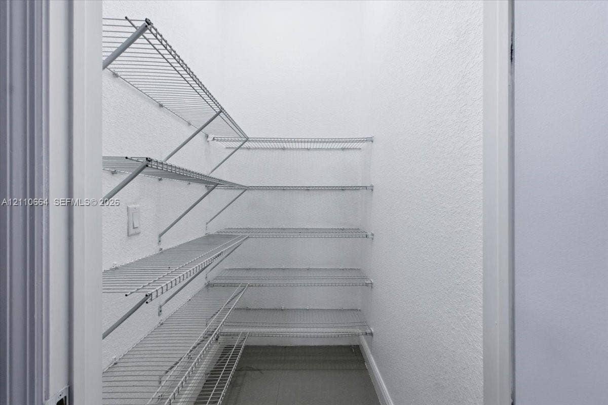 Walk-in storage pantry with multi-tiered wire shelving for convenient organization