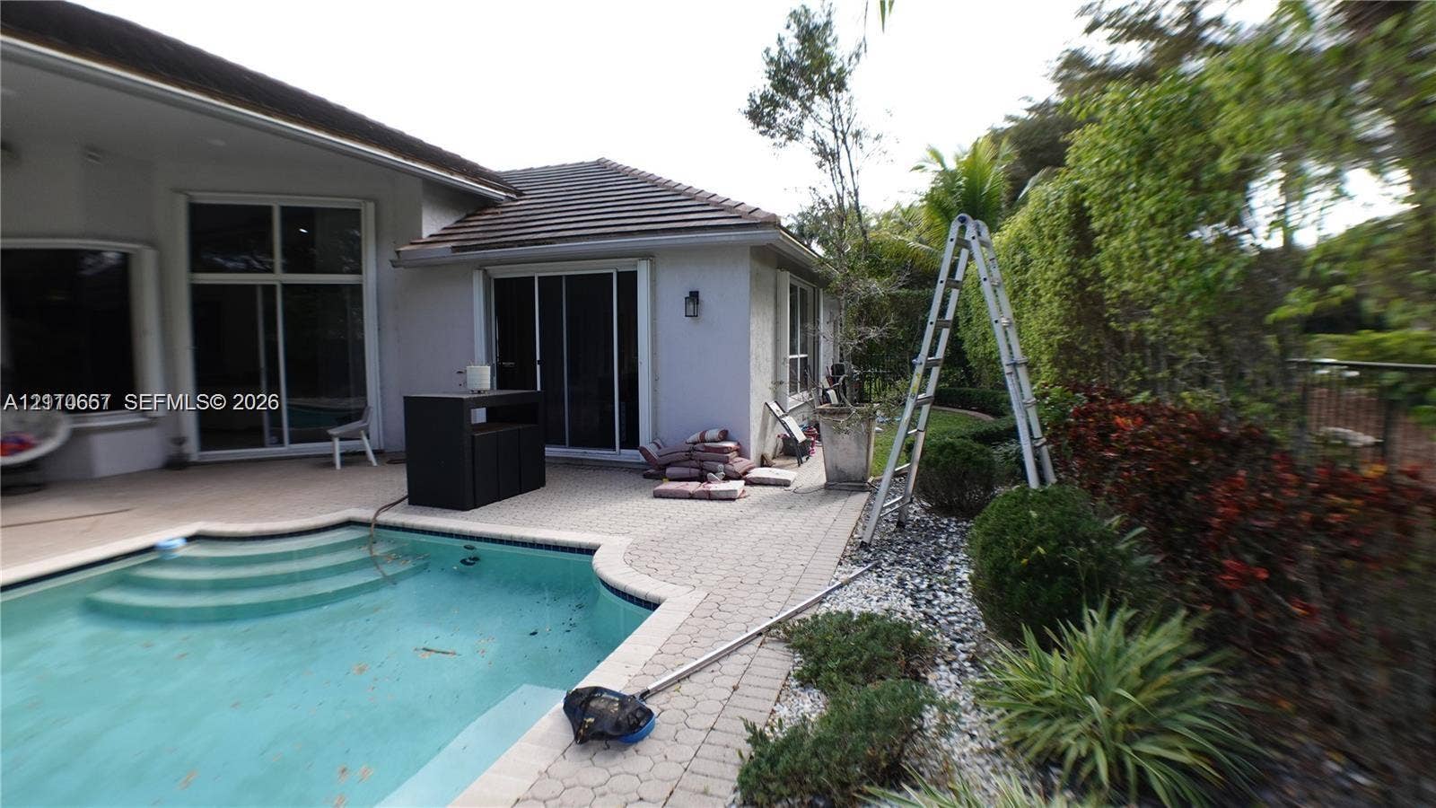 Dark wood-finish flooring and dual-pane window featuring exterior landscaping