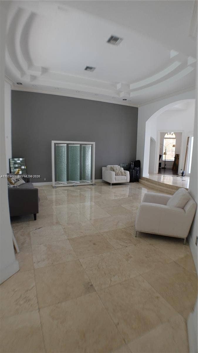 Arched windows, bay window configuration, and polished stone tile flooring