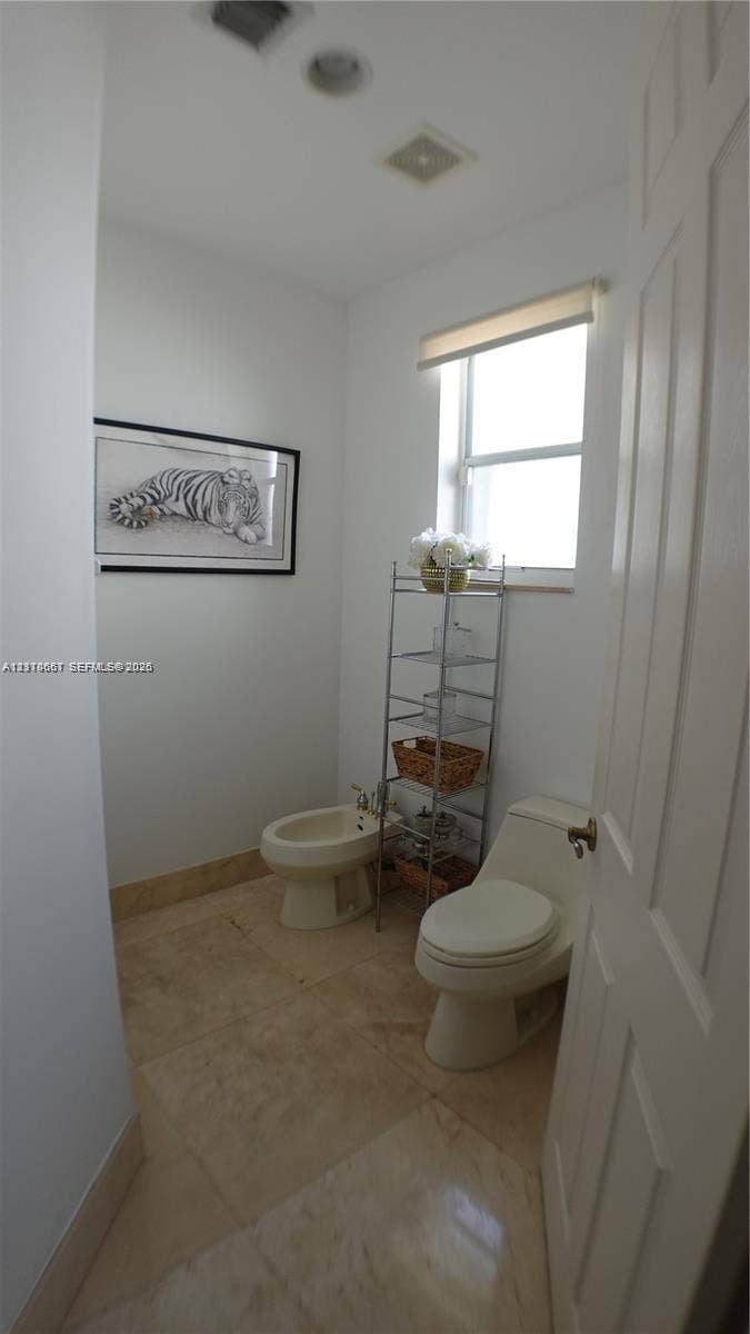 Bathroom featuring a vanity with integrated sink and stone-finish countertop, white cabinetry, framed mirror, and a shower stall with glass enclosure