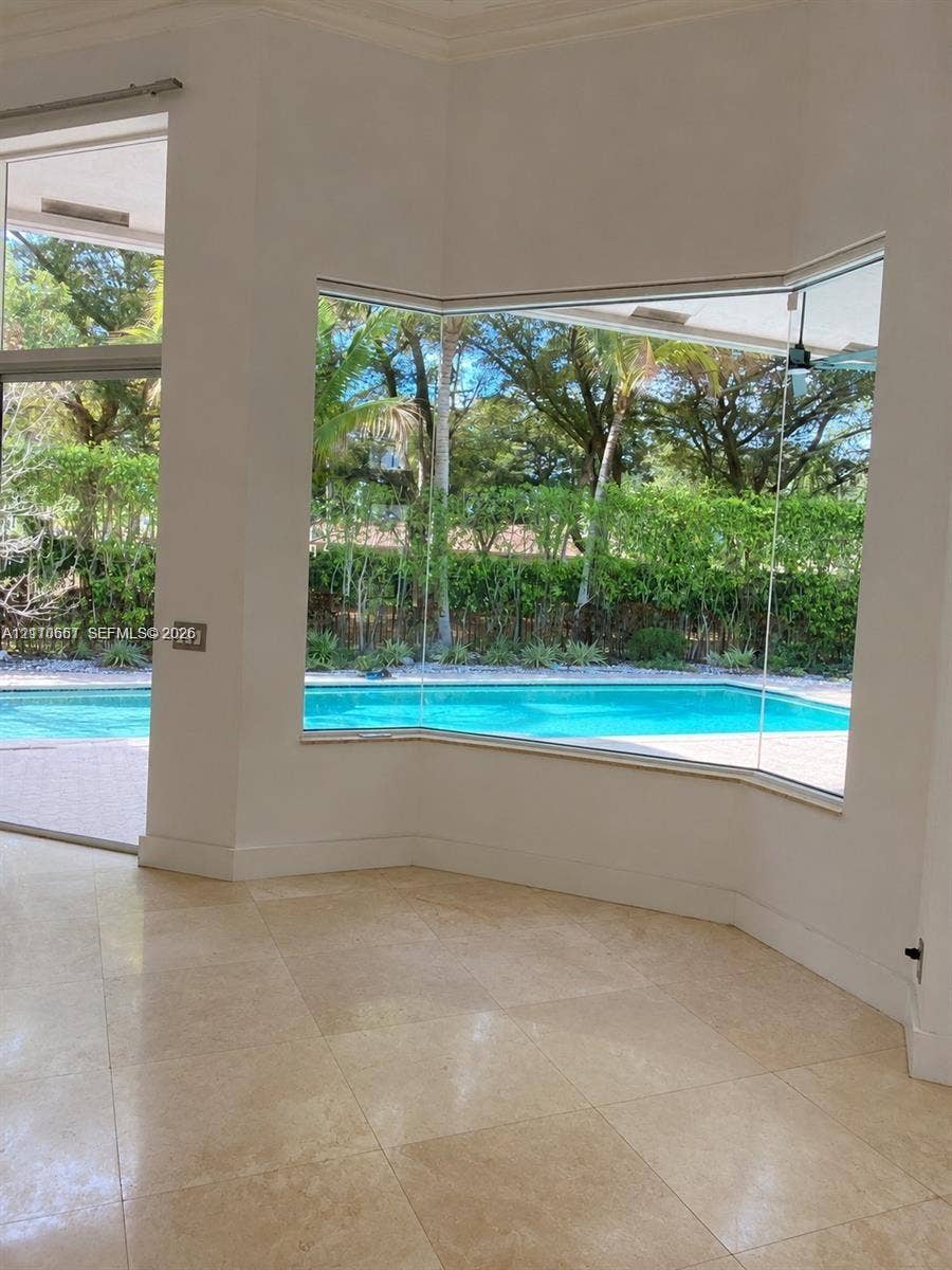 Vaulted ceiling, three arched windows, and wood-finish flooring