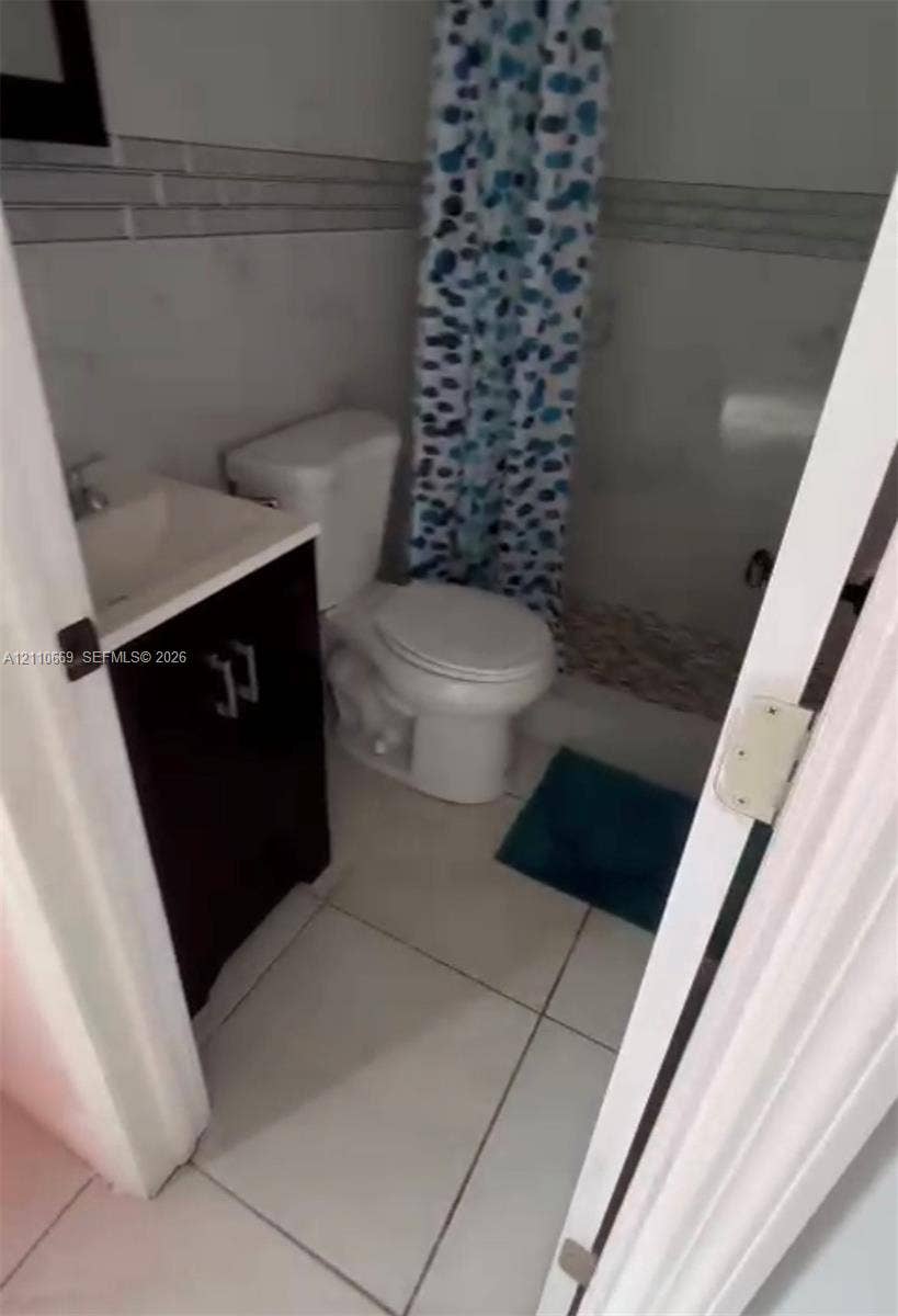 1635 Hollywood Boulevard, #B, Hollywood, Hollywood, FL 33020 Bathroom featuring a vanity with a rectangular sink, large-format floor tile, and tiled shower surround with horizontal decorative inlay