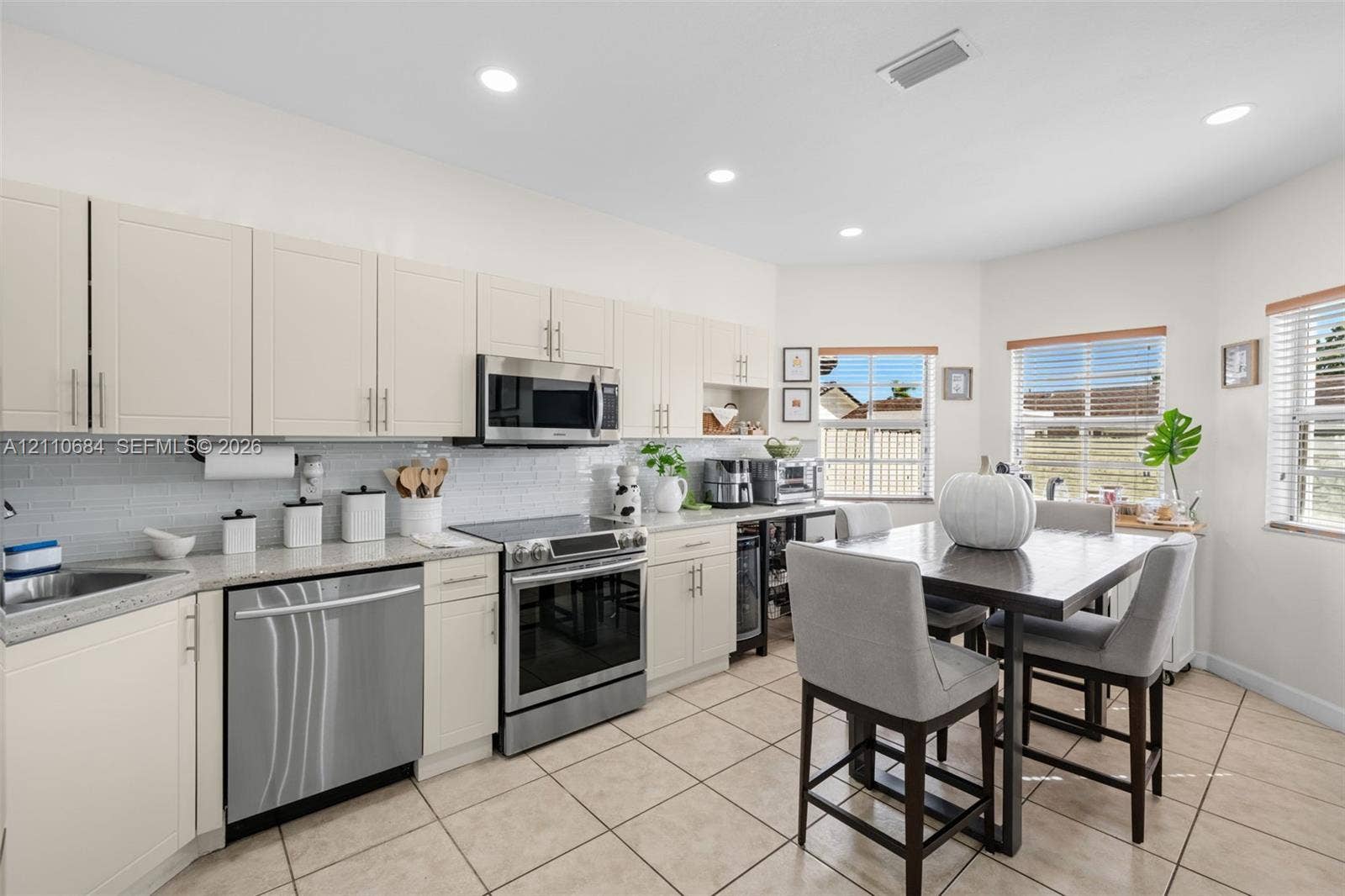 13542 SW 177th Terrace, Miami, FL 33177 Kitchen featuring light-toned shaker cabinetry, stone-finish countertops, stainless steel appliances, recessed ceiling lighting.