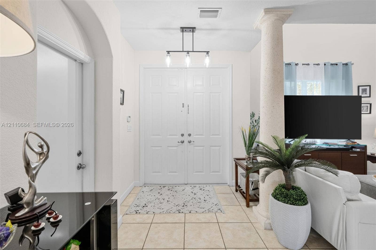 13542 SW 177th Terrace, Miami, FL 33177 Foyer featuring double entry doors, high ceilings, decorative stone-textured column, and tile flooring