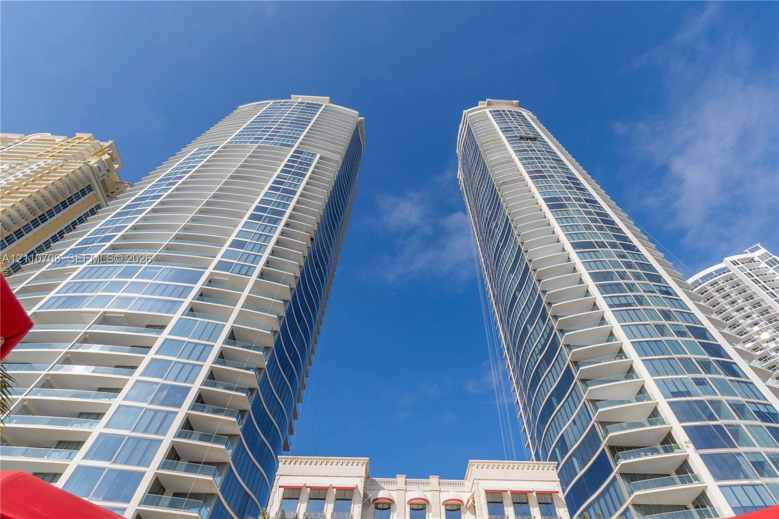 High-rise residential towers featuring blue-tinted glass curtain walls, white structural balconies, and tiered architectural detailing