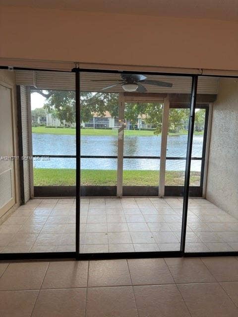 2297 SW 15th Street, #125, Deerfield Beach, Deerfield Beach, FL 33442 Screened patio with tile flooring and a ceiling fan, featuring a water-facing orientation