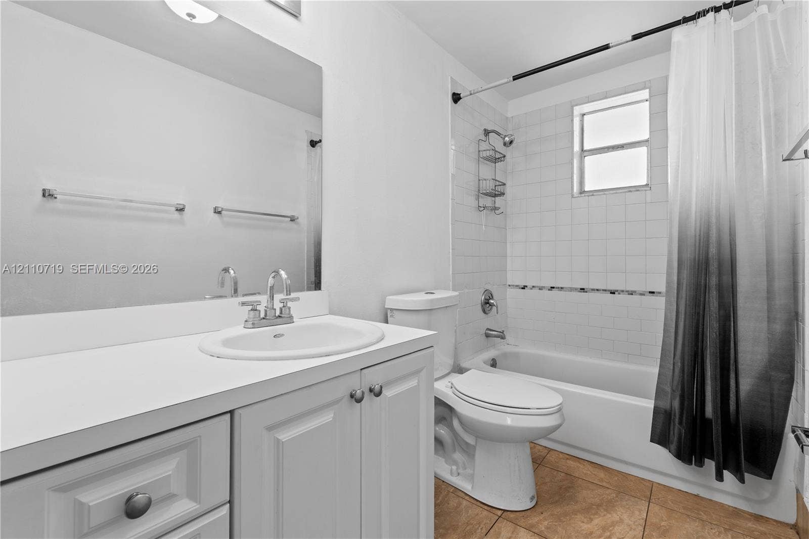 9375 Fontainebleau Boulevard, #L314, Miami, FL 33172 Bathroom featuring a white vanity with a solid surface countertop, an integrated sink, an expansive wall-mounted mirror, and a tub-shower combination with white wall tile