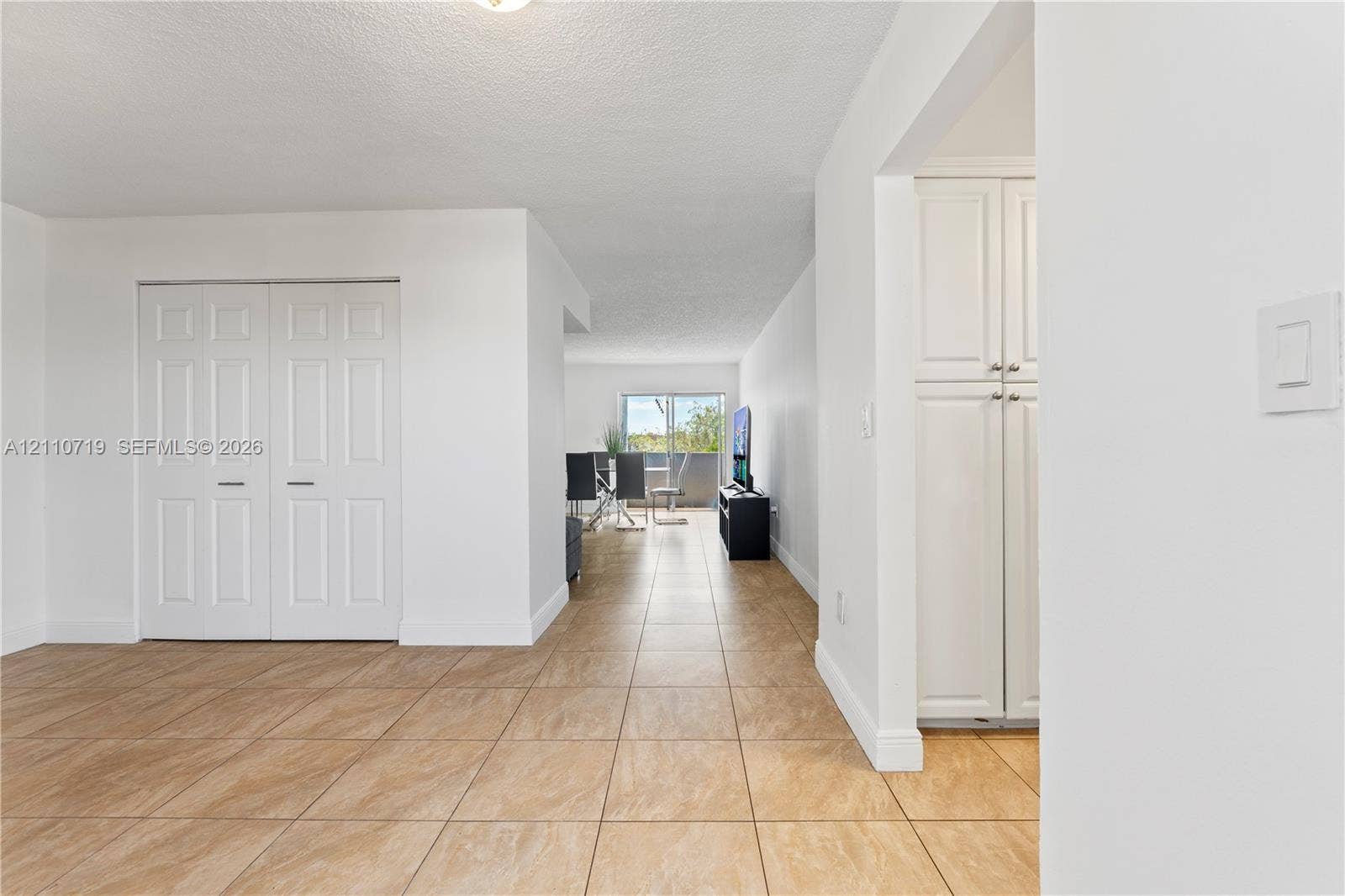 9375 Fontainebleau Boulevard, #L314, Miami, FL 33172 Ceramic tile flooring, white shaker-style cabinetry, and white paneled closet doors