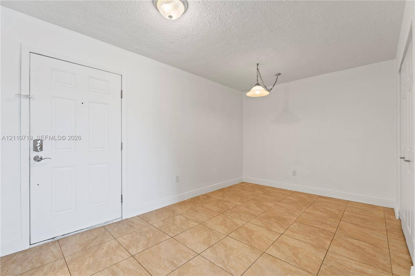 9375 Fontainebleau Boulevard, #L314, Miami, FL 33172 Neutral-toned ceramic tile flooring, solid-core entry door with integrated deadbolt hardware, ceiling-mounted dome light fixture, and pendant light with adjustable chain mount