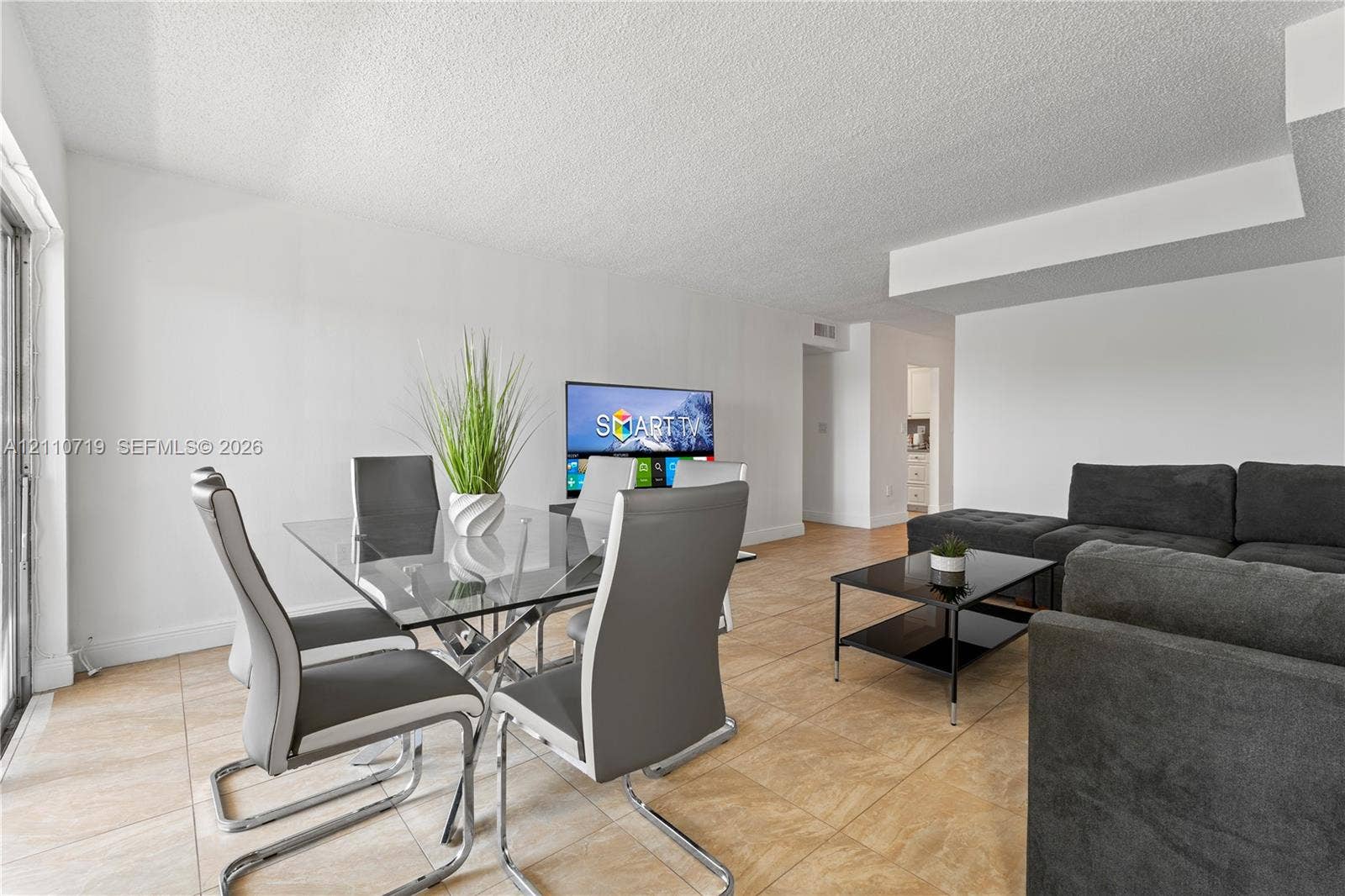 9375 Fontainebleau Boulevard, #L314, Miami, FL 33172 Neutral-toned ceramic tile flooring, clean white walls, and a glass-paneled sliding door