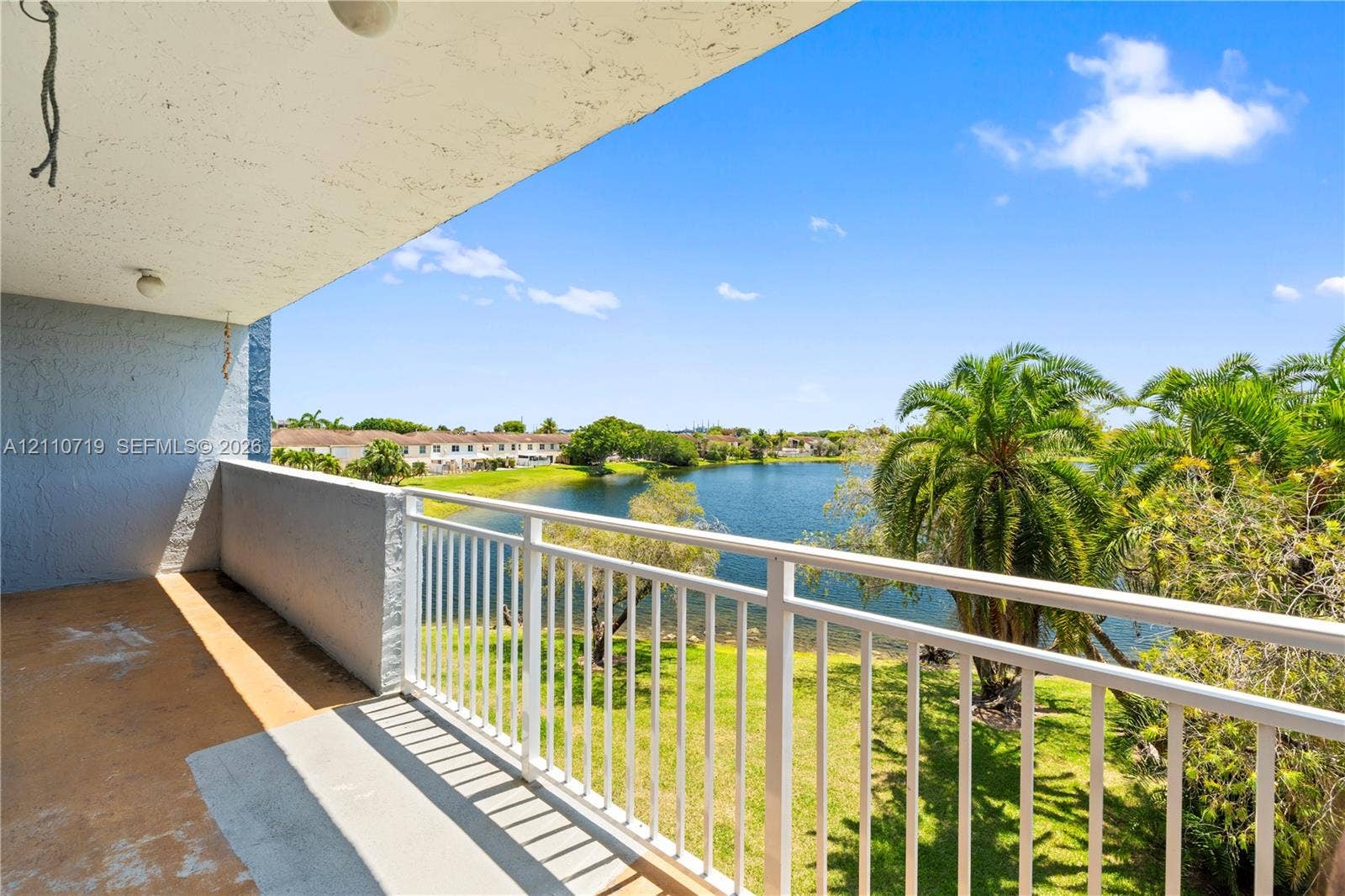 9375 Fontainebleau Boulevard, #L314, Miami, FL 33172 Covered balcony featuring a white metal railing, concrete flooring, and water frontage