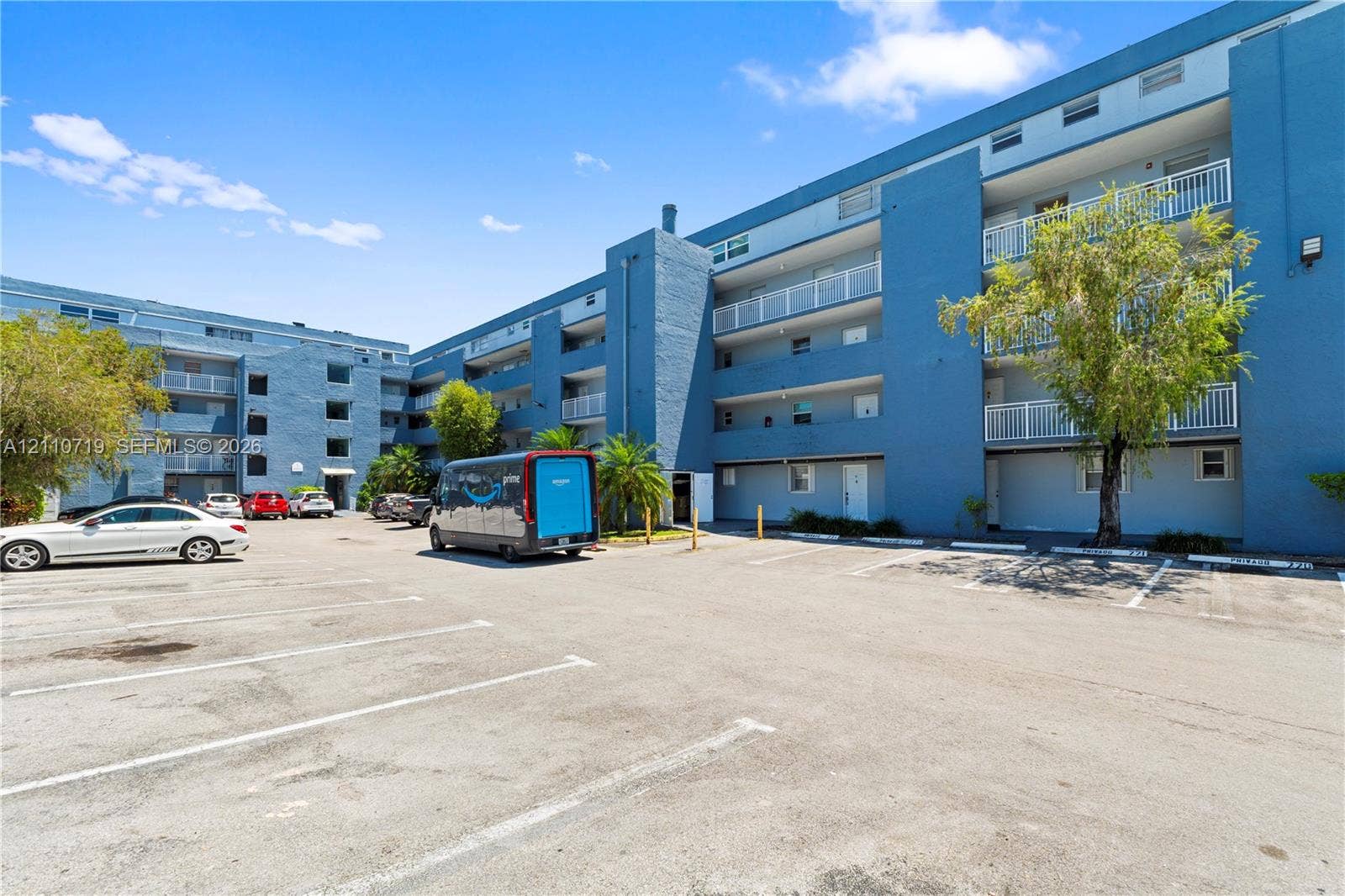 9375 Fontainebleau Boulevard, #L314, Miami, FL 33172 Multi-story residential building featuring painted masonry exterior, private balcony access, and an asphalt-paved surface parking lot