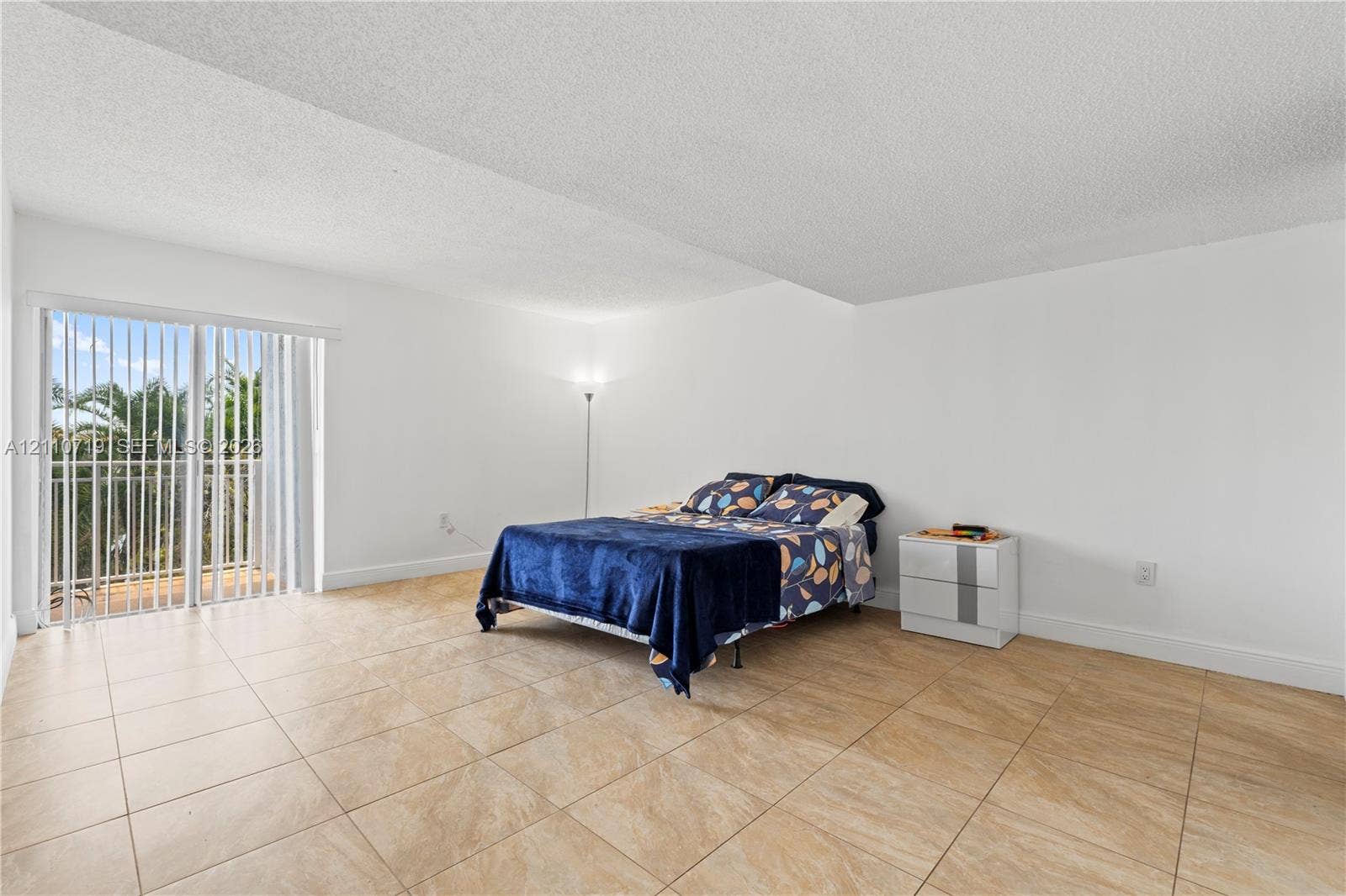9375 Fontainebleau Boulevard, #L314, Miami, FL 33172 Neutral-tone tile flooring, expansive wall space, and sliding glass door with a white-finished frame