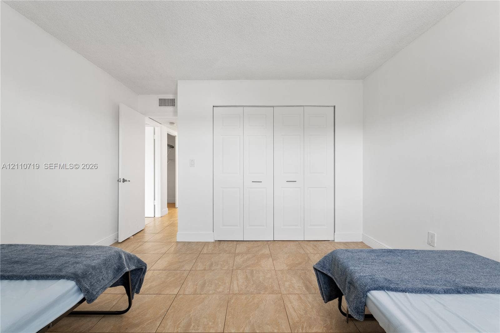 9375 Fontainebleau Boulevard, #L314, Miami, FL 33172 Interior room featuring neutral wall paint, tile flooring, and a large four-panel folding closet door