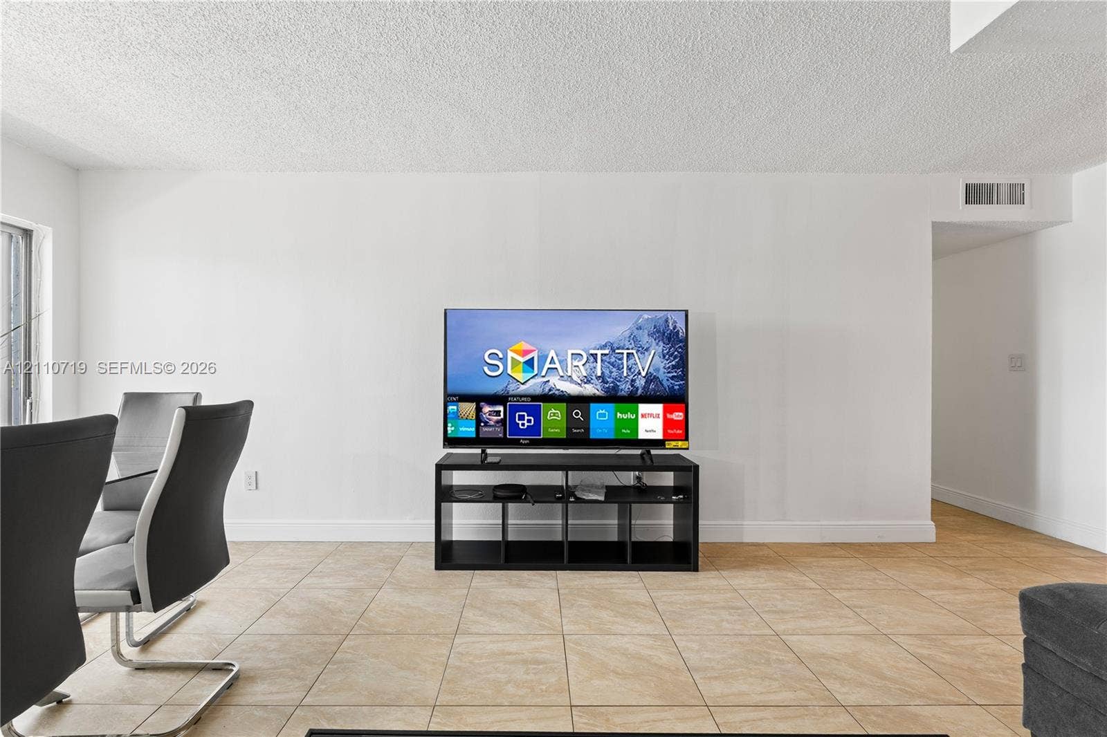 9375 Fontainebleau Boulevard, #L314, Miami, FL 33172 Neutral-toned ceramic tile flooring throughout an open-concept area with smooth white wall finishes