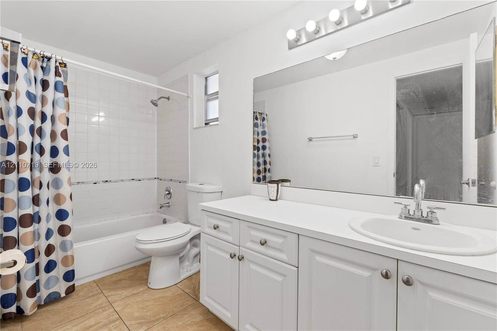 9375 Fontainebleau Boulevard, #L314, Miami, FL 33172 Bathroom featuring a white vanity cabinet with an integrated sink, polished chrome faucet, large vanity mirror, tile flooring, and a tub-shower combination with white wall tile
