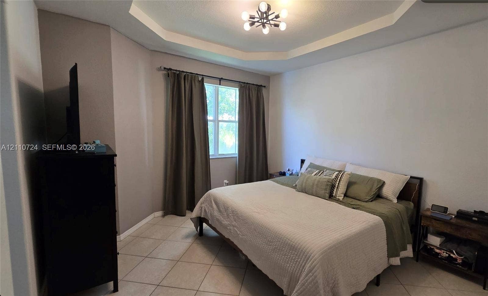 10846 SW 240th Lane, Homestead, FL 33032 Tray ceiling featuring a multi-arm modern light fixture, neutral wall palette, and large-format tile flooring
