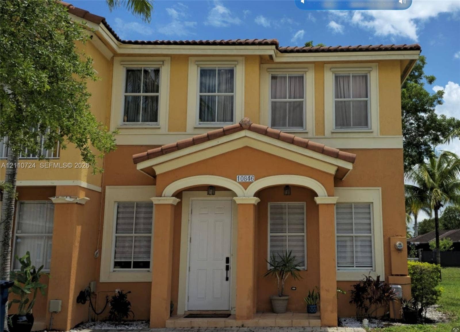 10846 SW 240th Lane, Homestead, FL 33032 Two-story exterior featuring a stucco facade, covered entryway with arched portico, column supports, and a tile roof