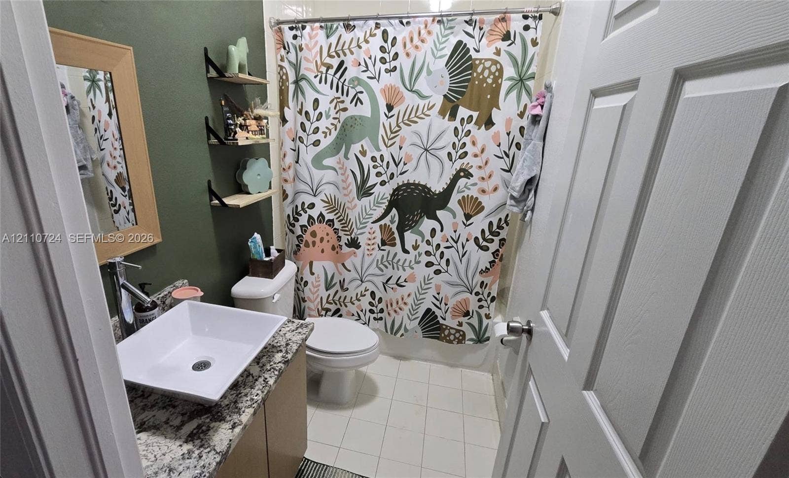 10846 SW 240th Lane, Homestead, FL 33032 Bathroom featuring a stone-look countertop, a square vessel sink with a chrome faucet, three tiered wall-mounted corner shelves, and tile flooring