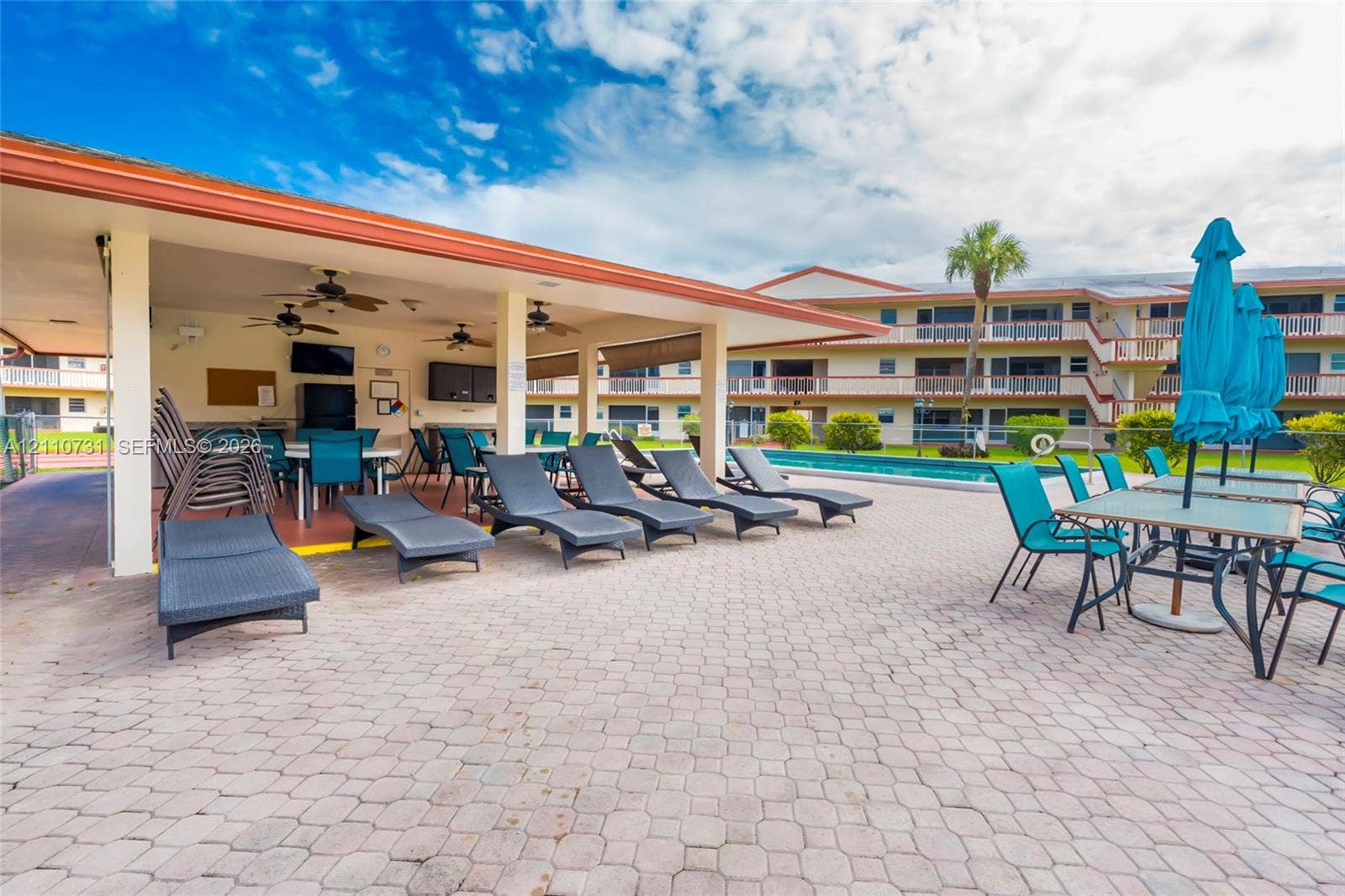 Outdoor covered pavilion featuring recessed lighting, ceiling-mounted fans, a brick paver patio, and a swimming pool