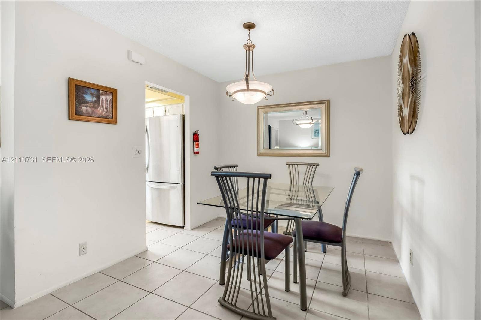 Dining area featuring ceramic tile flooring, a multi-light metal pendant fixture, and a neutral color palette