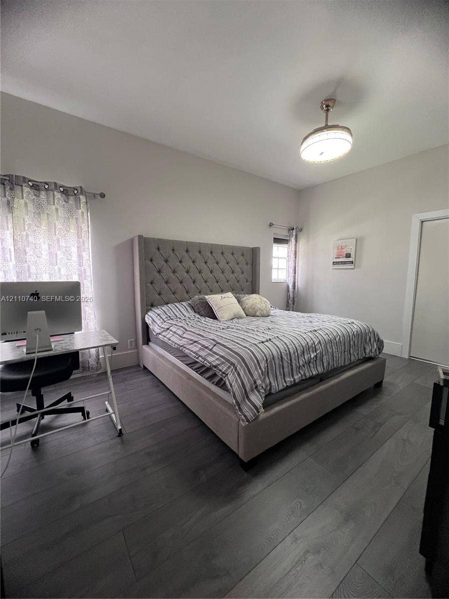 Wood-finish plank flooring, neutral wall tones, and overhead semi-flush mount lighting