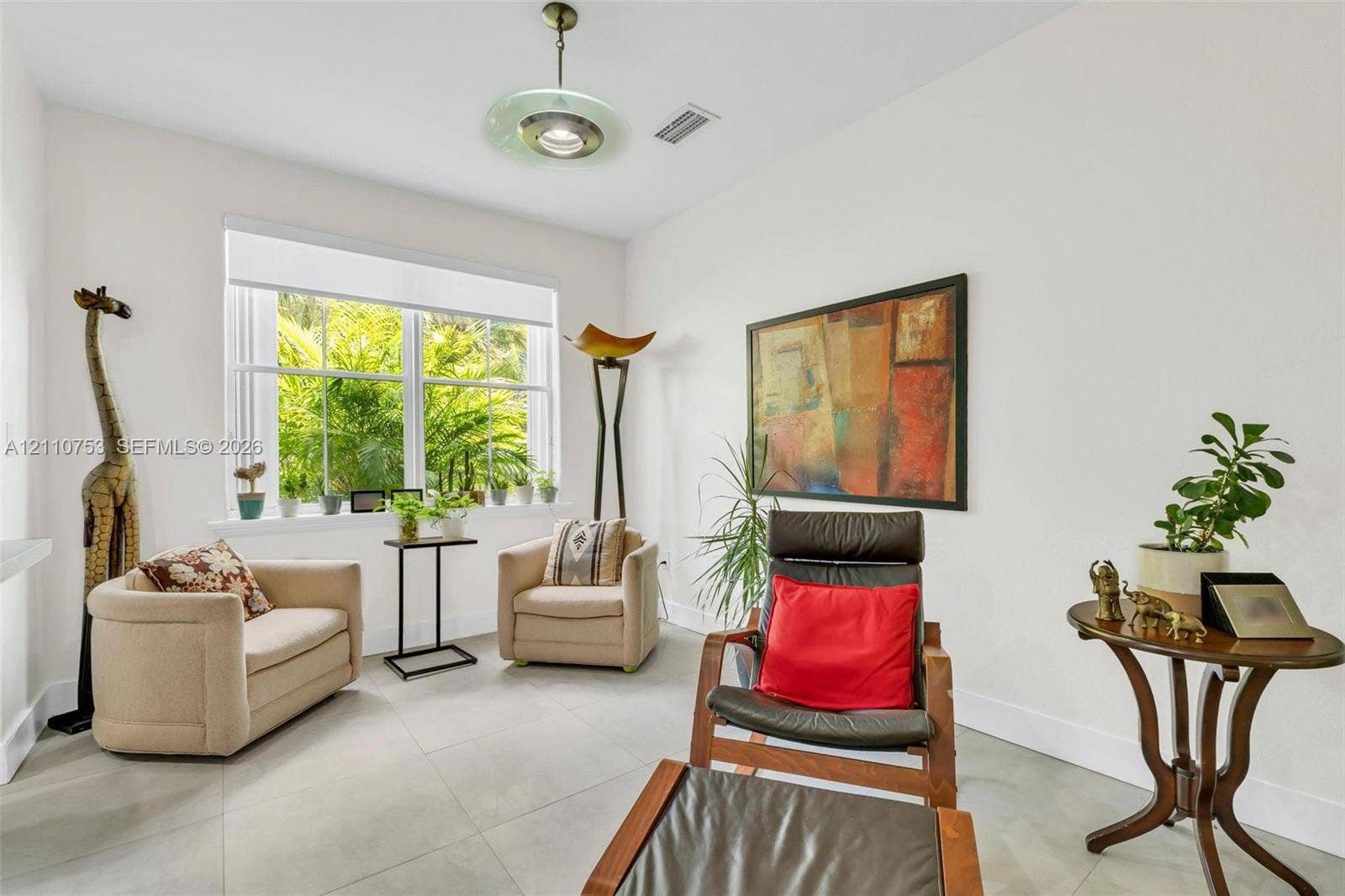 Large-format tile flooring, oversized double-pane windows, and a multi-tiered brushed metal ceiling light fixture