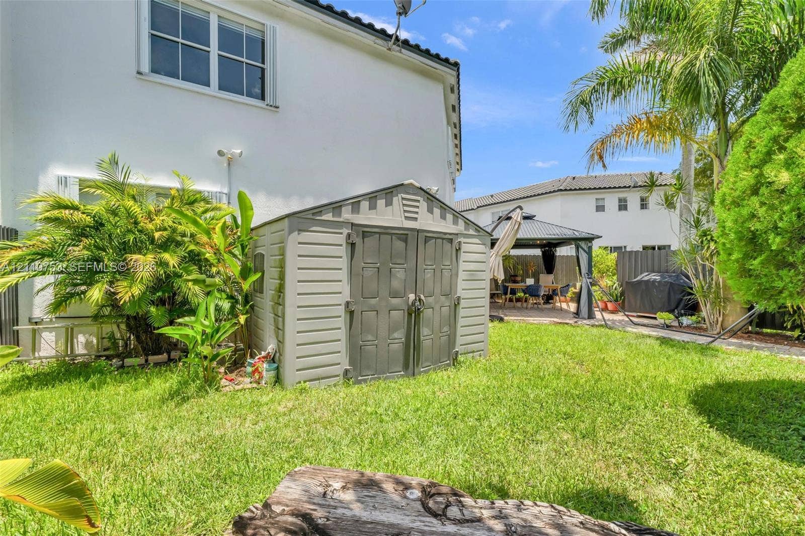 Backyard featuring a grass lawn, permanent storage shed, and a metal-framed gazebo