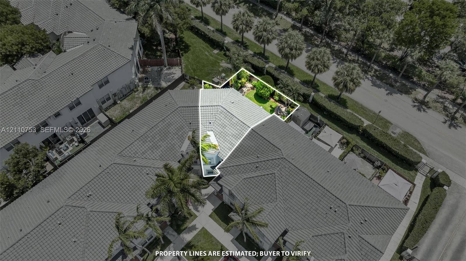 Aerial view of property featuring a tile roof and a fenced, landscaped yard area
