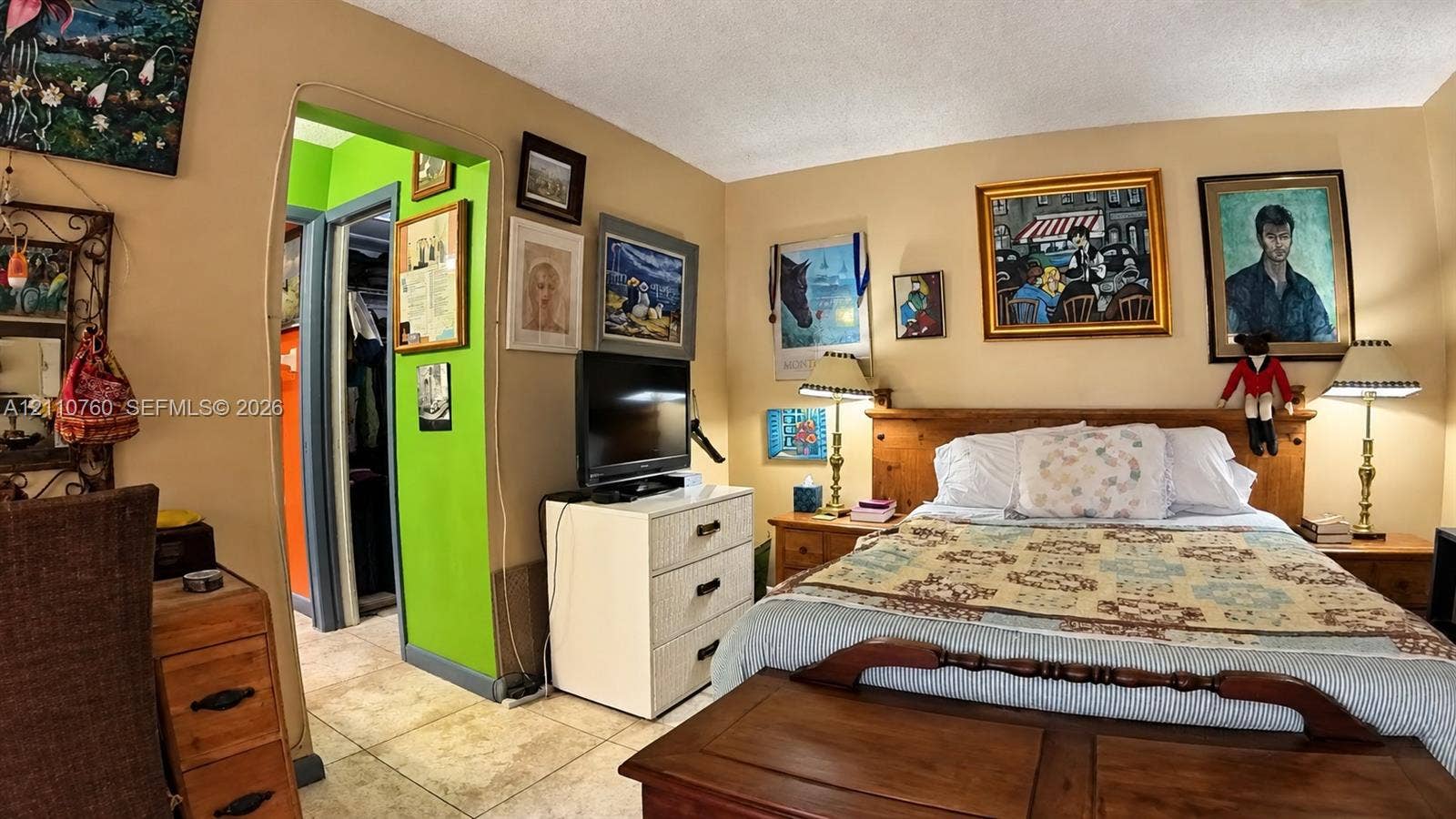 Interior space featuring neutral-toned walls, tile flooring, and a walk-in closet with integrated storage