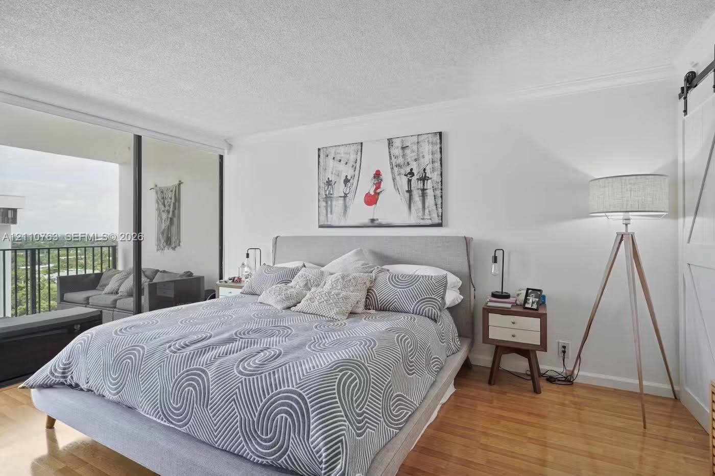 1901 Brickell Avenue, #B1706, Miami, FL 33129 Wood-finish flooring, floor-to-ceiling glass sliding doors, private balcony, and white sliding barn door
