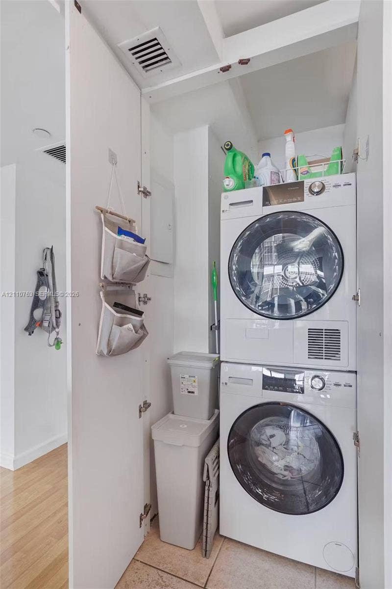 1901 Brickell Avenue, #B1706, Miami, FL 33129 Dedicated laundry closet featuring a stacked front-loading washer and dryer set with tile flooring