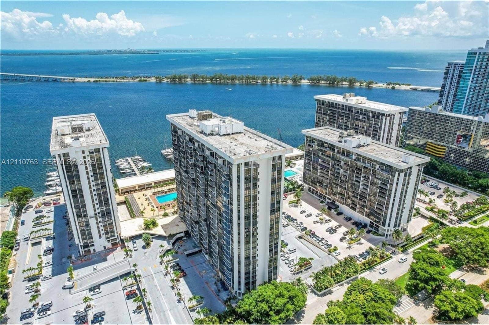 1901 Brickell Avenue, #B1706, Miami, FL 33129 High-rise residential complex featuring waterfront positioning, private surface parking, an outdoor swimming pool, and dedicated boat slips