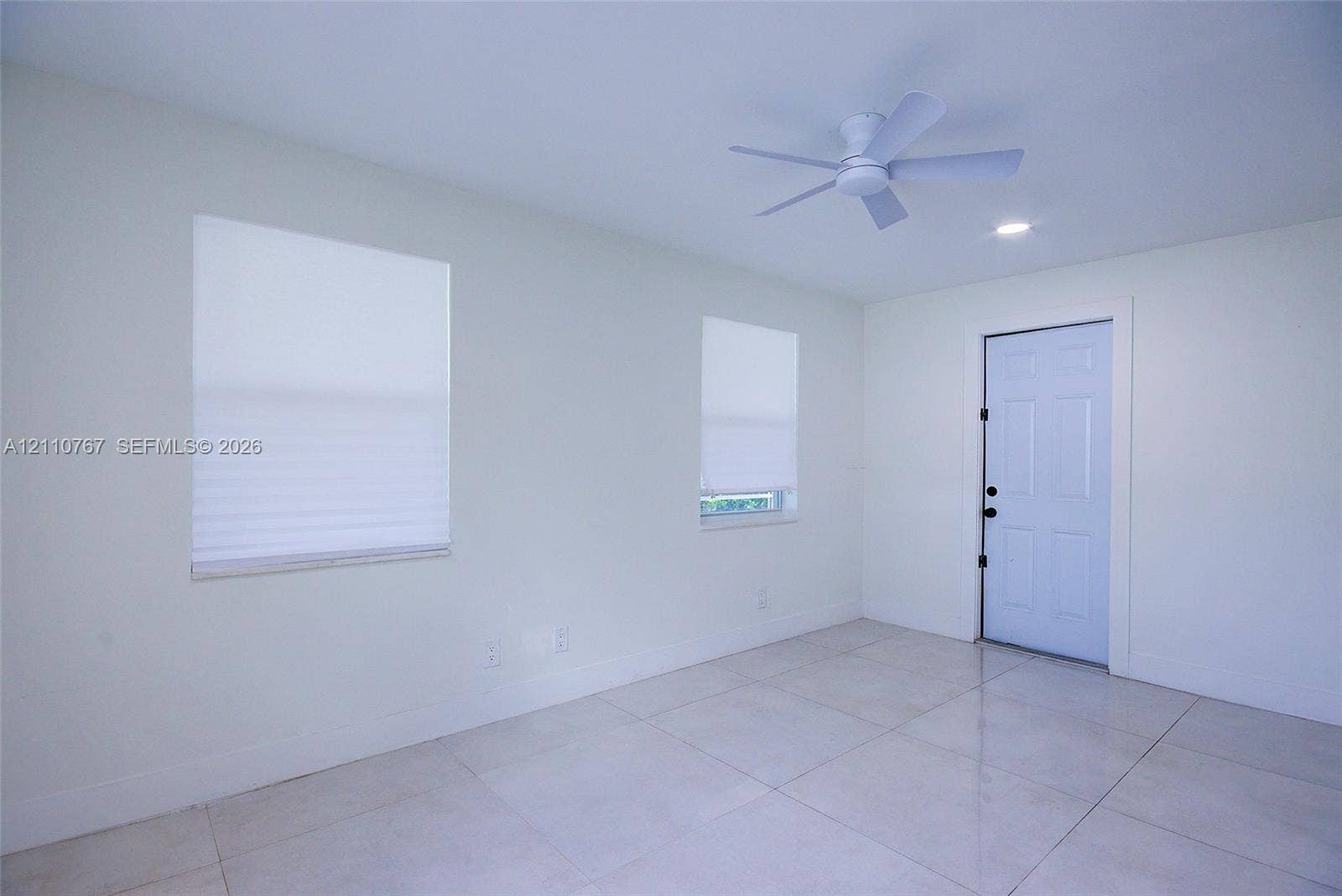 5305 Cleveland Road, Delray Beach, FL 33484 Light-filled room featuring neutral tile flooring, a six-panel exterior door, a multi-blade ceiling fan, and recessed lighting