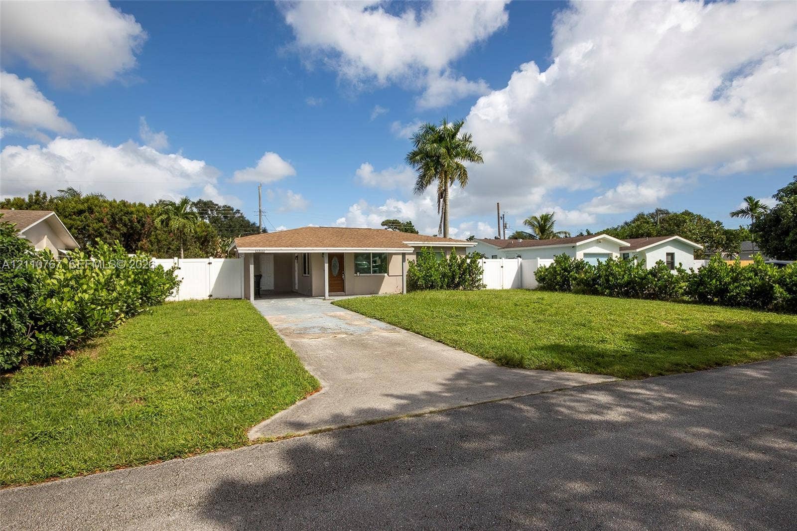 5305 Cleveland Road, Delray Beach, FL 33484 Single-story exterior featuring a hip roof, covered front entryway, concrete driveway, and white vinyl privacy fencing