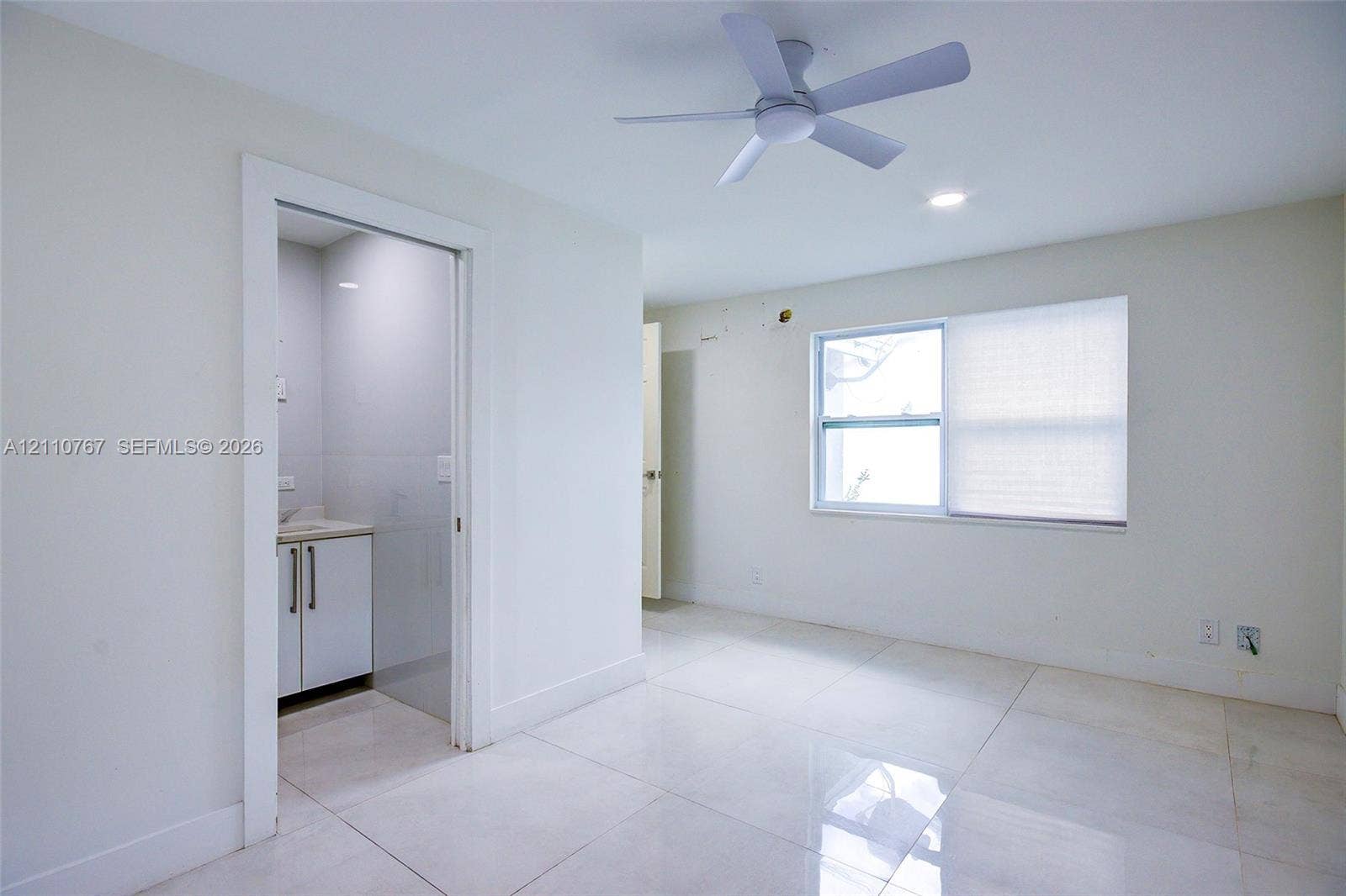 5305 Cleveland Road, Delray Beach, FL 33484 Interior space featuring white tile flooring, recessed ceiling lighting, a three-blade ceiling fan, and a single-hung window with shades