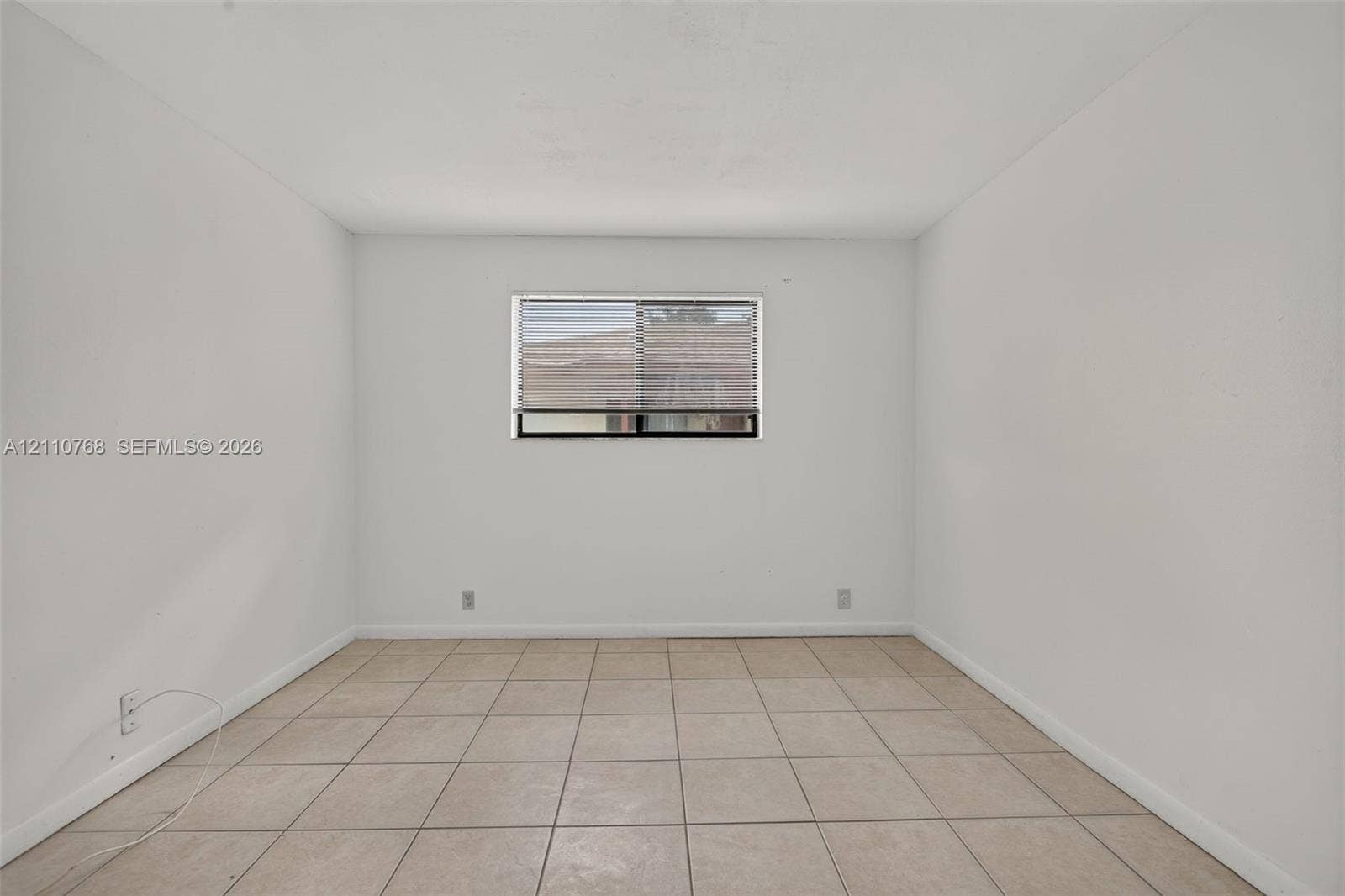 2070 NW 43rd Terrace, #7, Lauderhill, FL 33313 Neutral interior space featuring light-toned floor tile and a central window with horizontal blinds